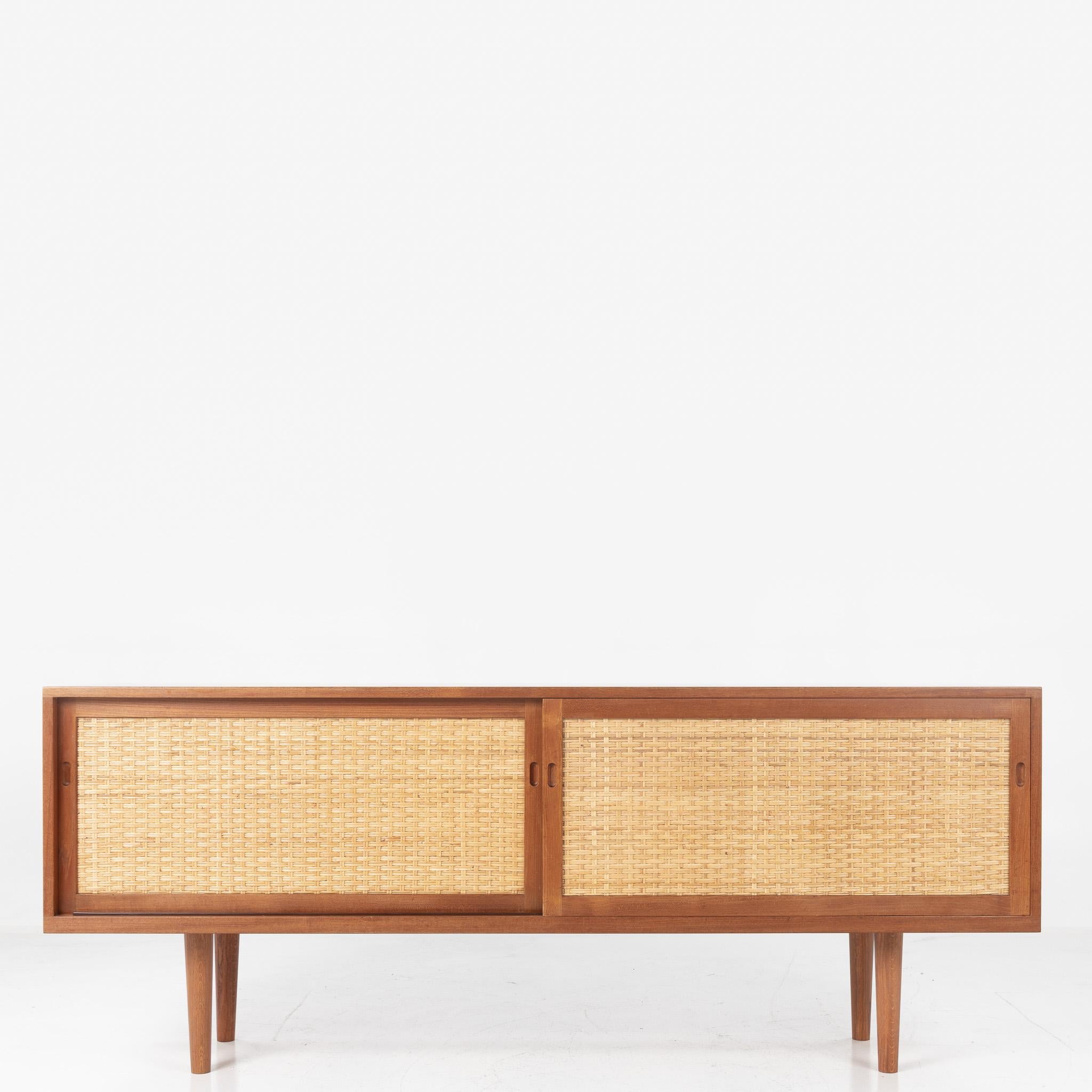 RY 26 - Sideboard in teak with decor and two sliding doors in patinated cane. Architect Hans J. Wegner for Ry Møbler.