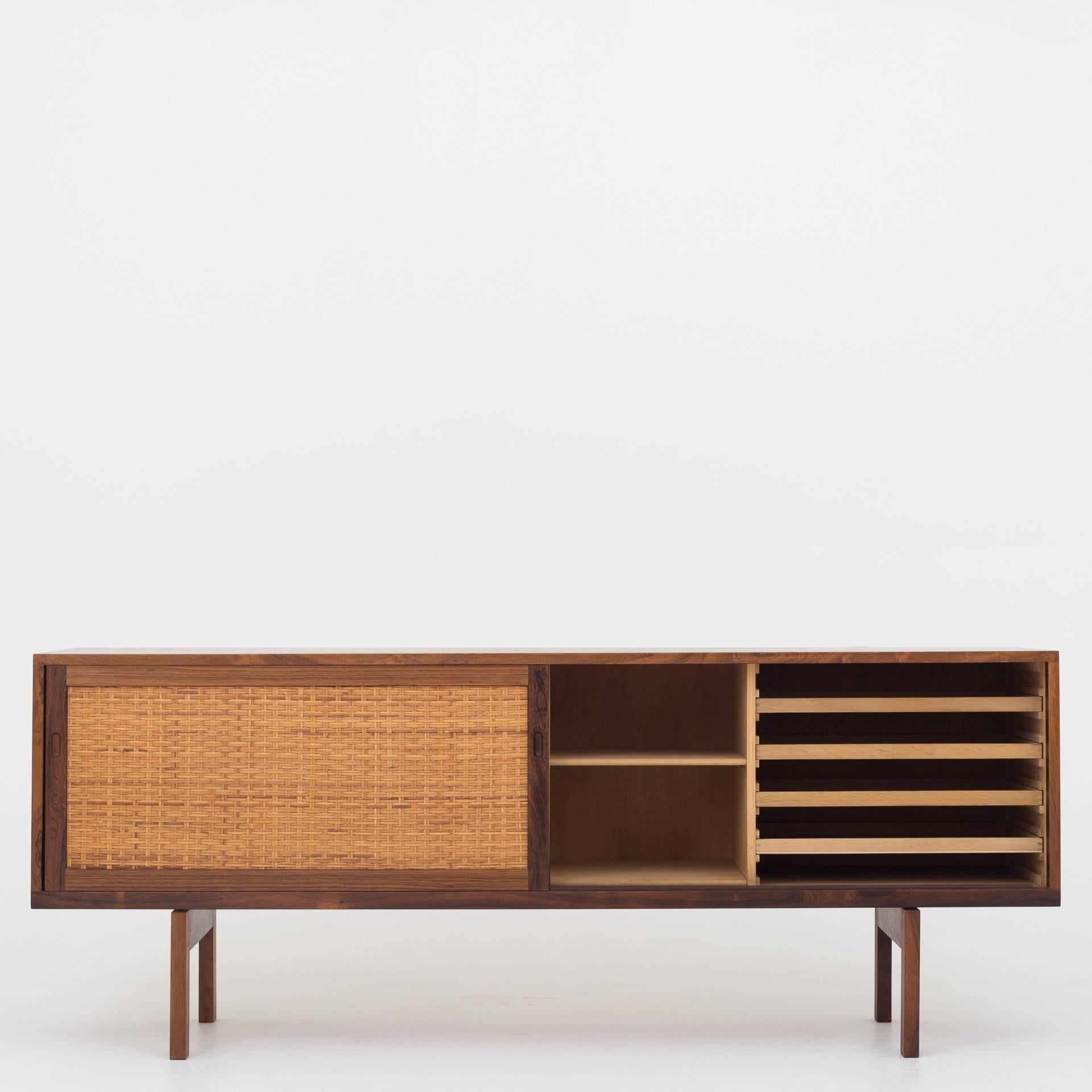 Sideboard in rosewood with two sliding doors with cane. Maker Ry Møbler.
