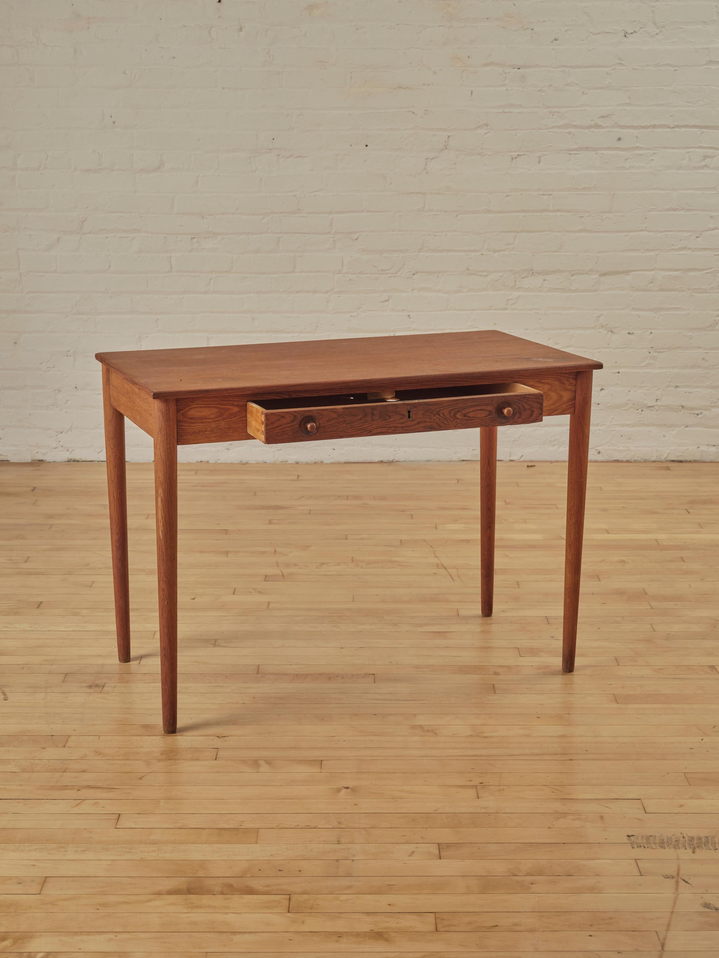 Oak desk by Hans Wegner for Ry Mobler. The legs, drawers, and frame are made from solid, patinated oak, while the top features an oak veneer desktop.