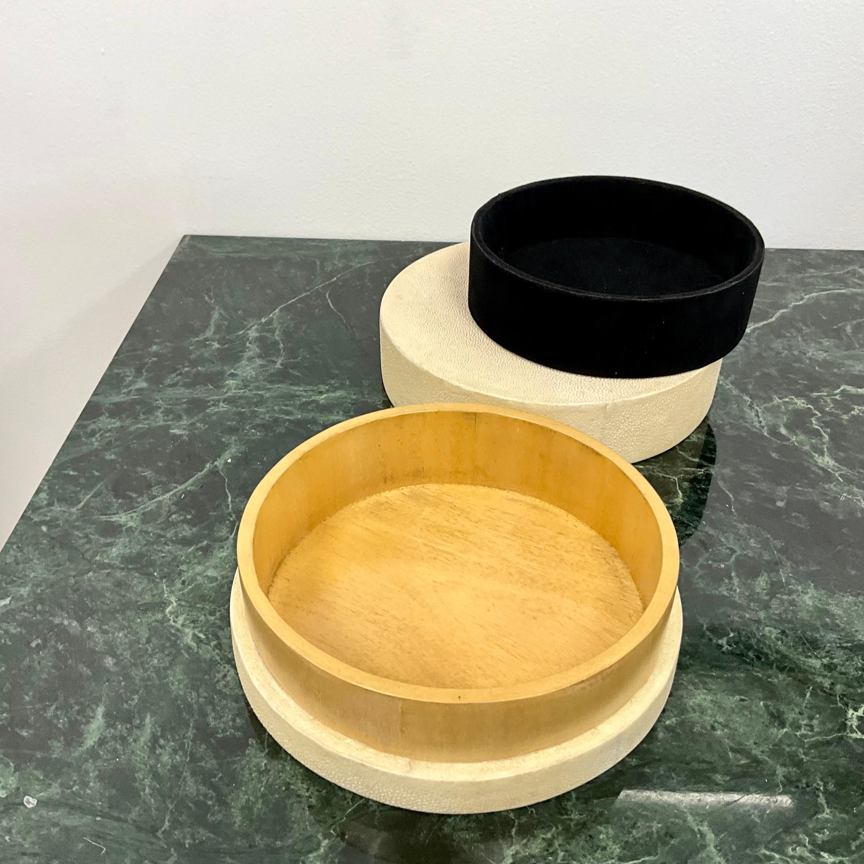 Circular lidded wood box covered in ivory colored Shagreen from R & Y  Augousti.  The interior having a felt removable liner.  Measuring 7.25” diameter x 3” high.

R&Y Augousti was founded in 1989 by husband and wife duo Rita & Yiouri Augousti. 