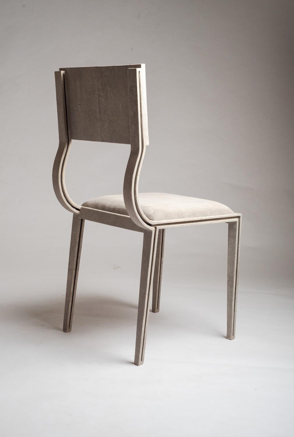 The Lola chair mixes elegance and comfort. Perfect for your dining room. The antique natural shagreen legs are unique and subtle with it's indentation details that complement the overall piece. The seat is upholstered in a luxurious soft cream linen