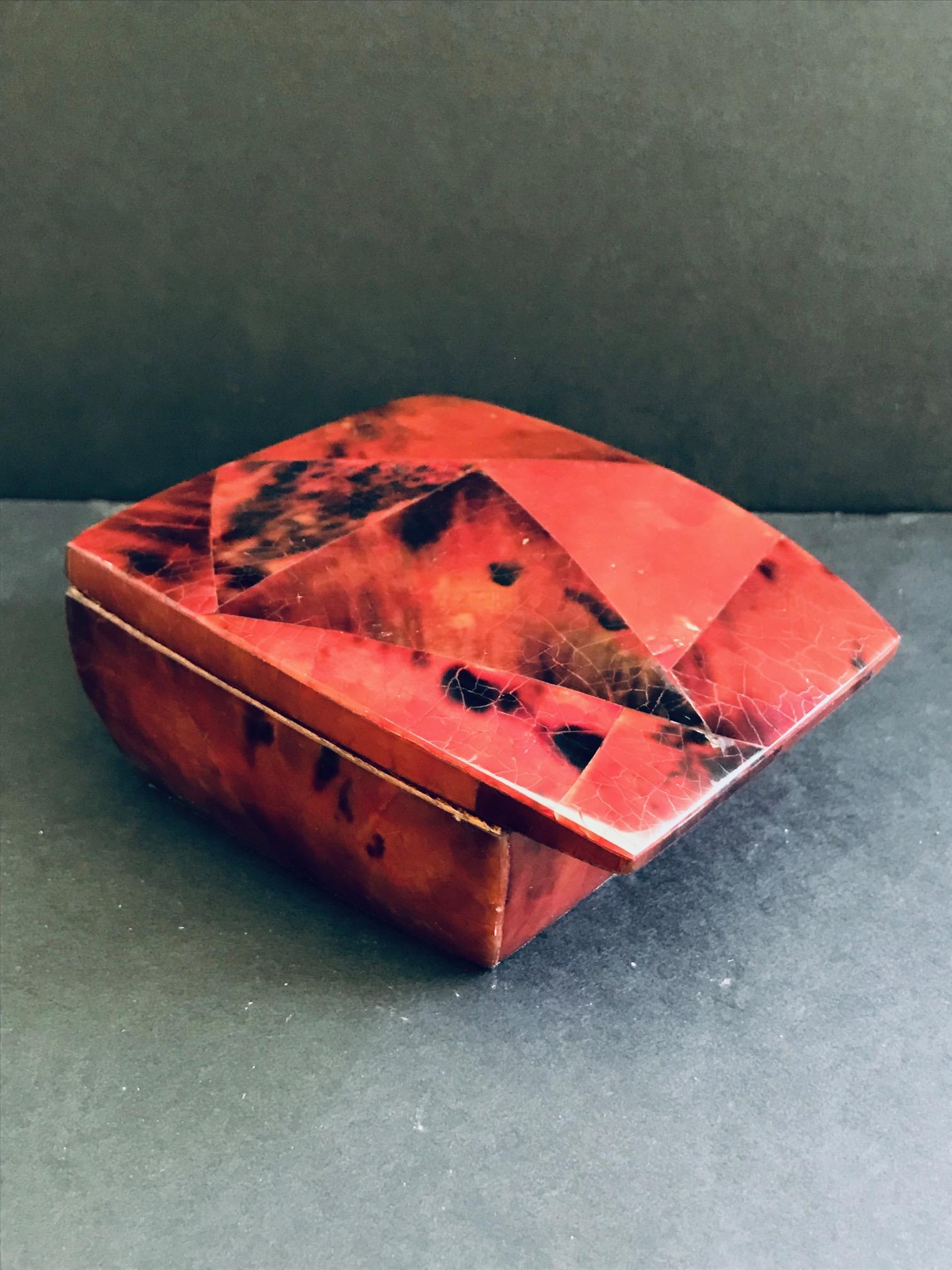 Beautiful jewelry box with hinged lid in lacquered pen-shell. Handcrafted in exotic materials with mosaic inlays in red and black. Streamline design features overlapping lid with palmwood frame with gold brass interior. Signed R&Y Augousti on