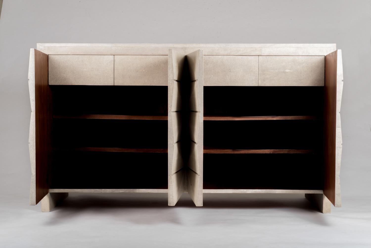 Le buffet Tomboy 8 est le meuble de rangement de luxe par excellence. Les détails géométriques de la porte sont subtils dans la finition crème du galuchat, mais ajoutent une touche d'originalité au buffet Classic. L'intérieur est en placage de bois