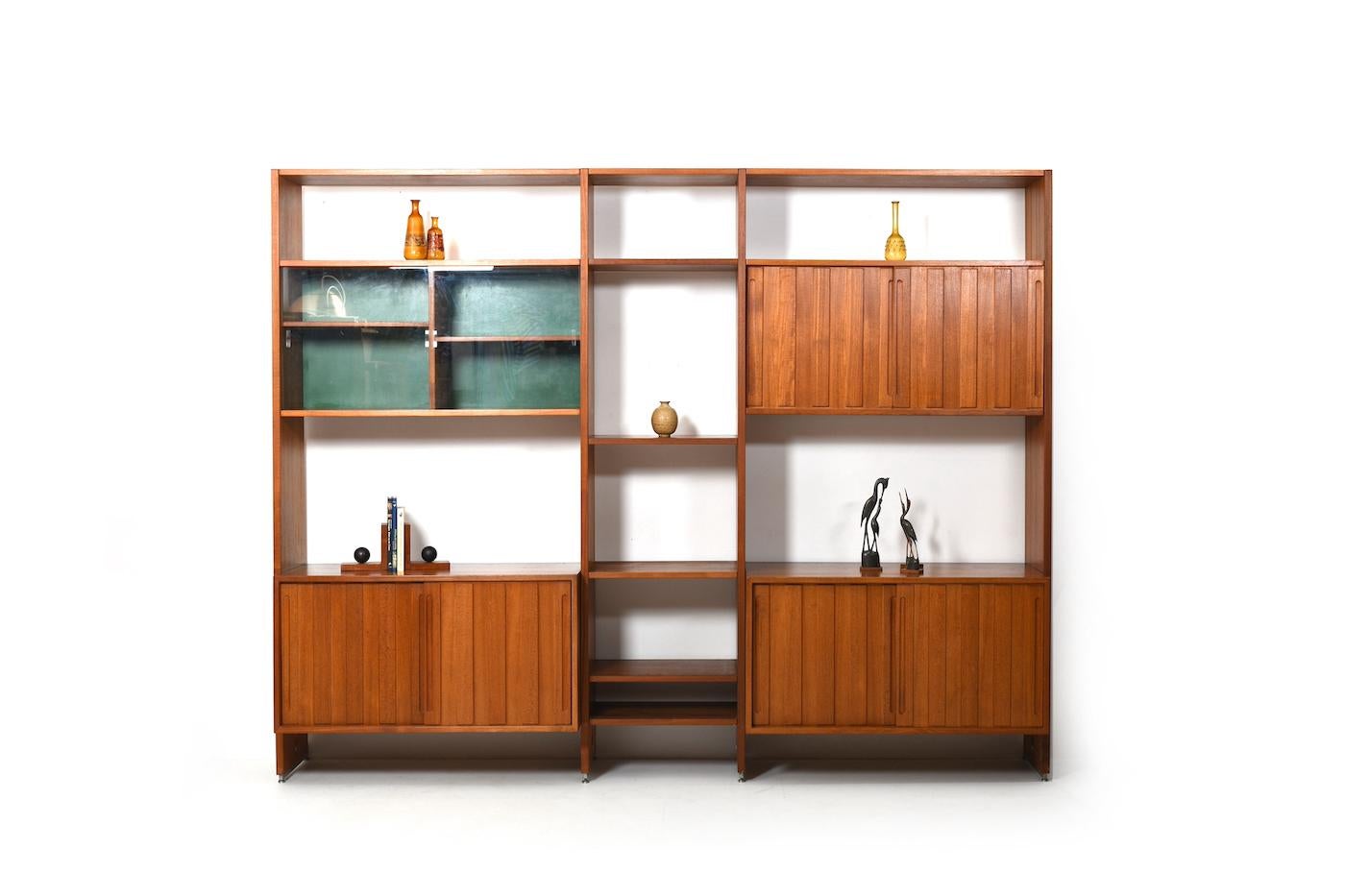 Danish wall unit in teak. Designed by Hans J.Wegner, manufactured by Ry Møbler. Mod. RY100 Denmark, 1960s.
The wall system consists of 4 cabinets (inside with shelves, one with glass doors) and a smaller middle part with just shelves (5 pcs.).