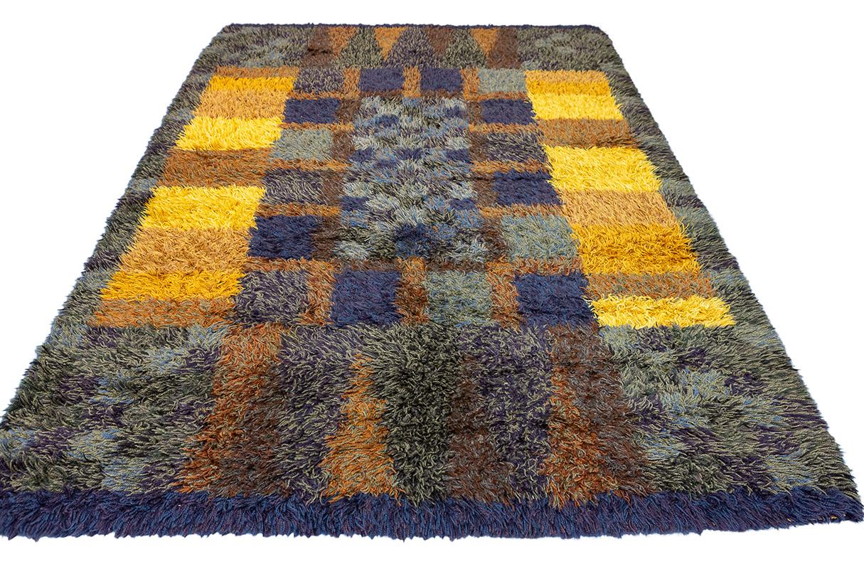 Vintage Rya Rug – 243 × 164 cm 
A stunning example of mid-century Scandinavian textile design, this hand-knotted Rya rug showcases a deeply textured pile and a vibrant yet earthy palette. Its striking checkerboard composition blends mustard yellow,