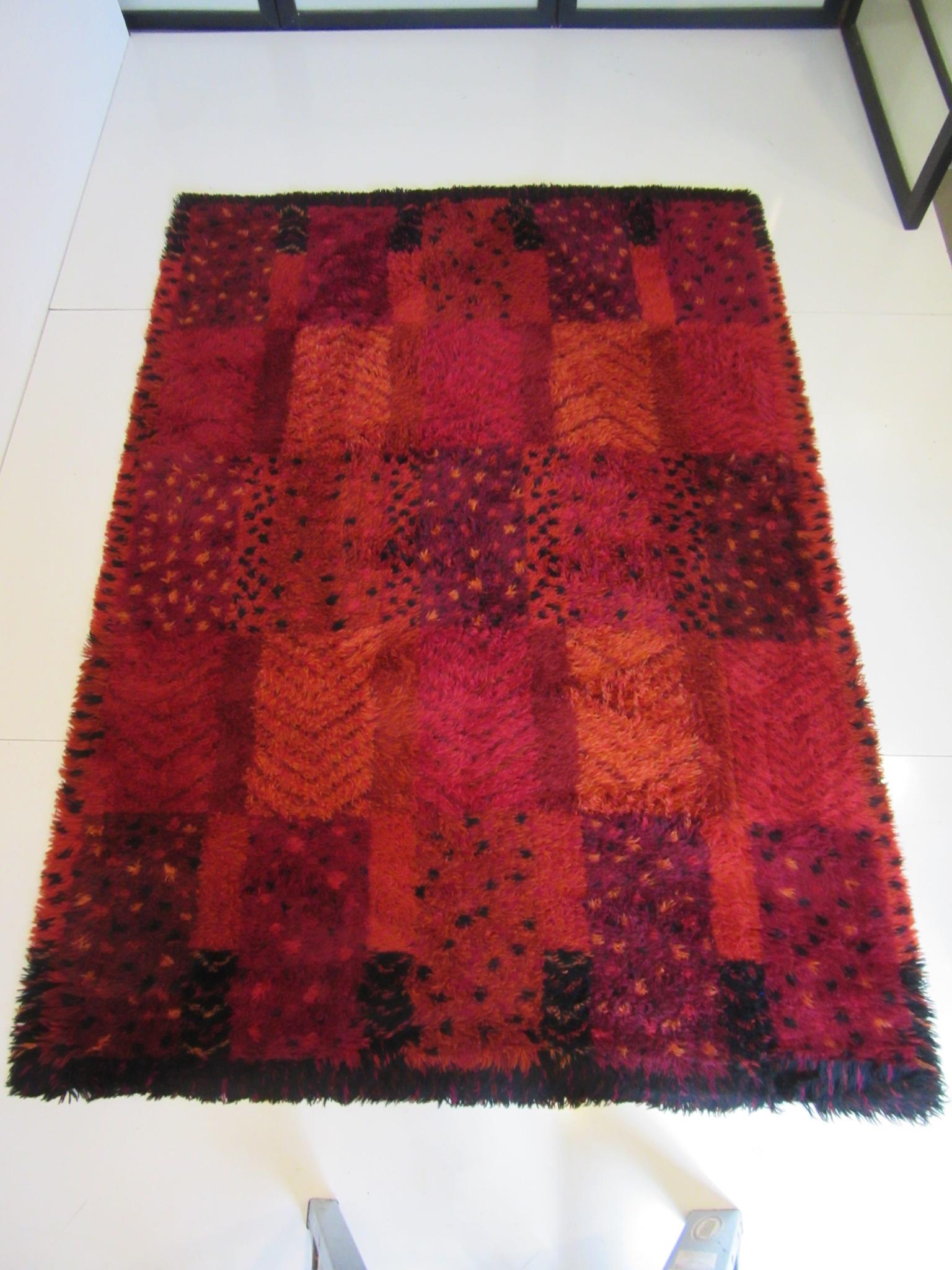 A well woven high pile Rya rug in a mult mix of reds, black and deep toned scarlet / purple called Alvastra red. Designed by Mairanne Richter (1916-2010) who worked closely with famed artist designer Marta Maas Fjetterstrom at the Helsing Borg