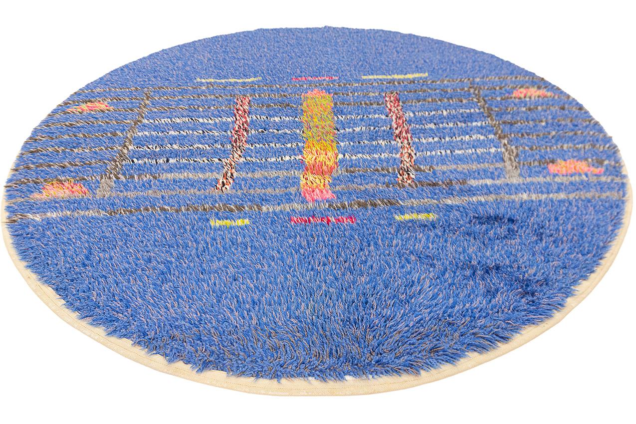Il s'agit d'un extraordinaire tapis suédois arrondi de Rya, qui se distingue par sa couleur de fond bleue enchanteresse et qui est orné d'un motif musical spécial captivant. Cette pièce exceptionnelle présente un mélange harmonieux d'artisanat