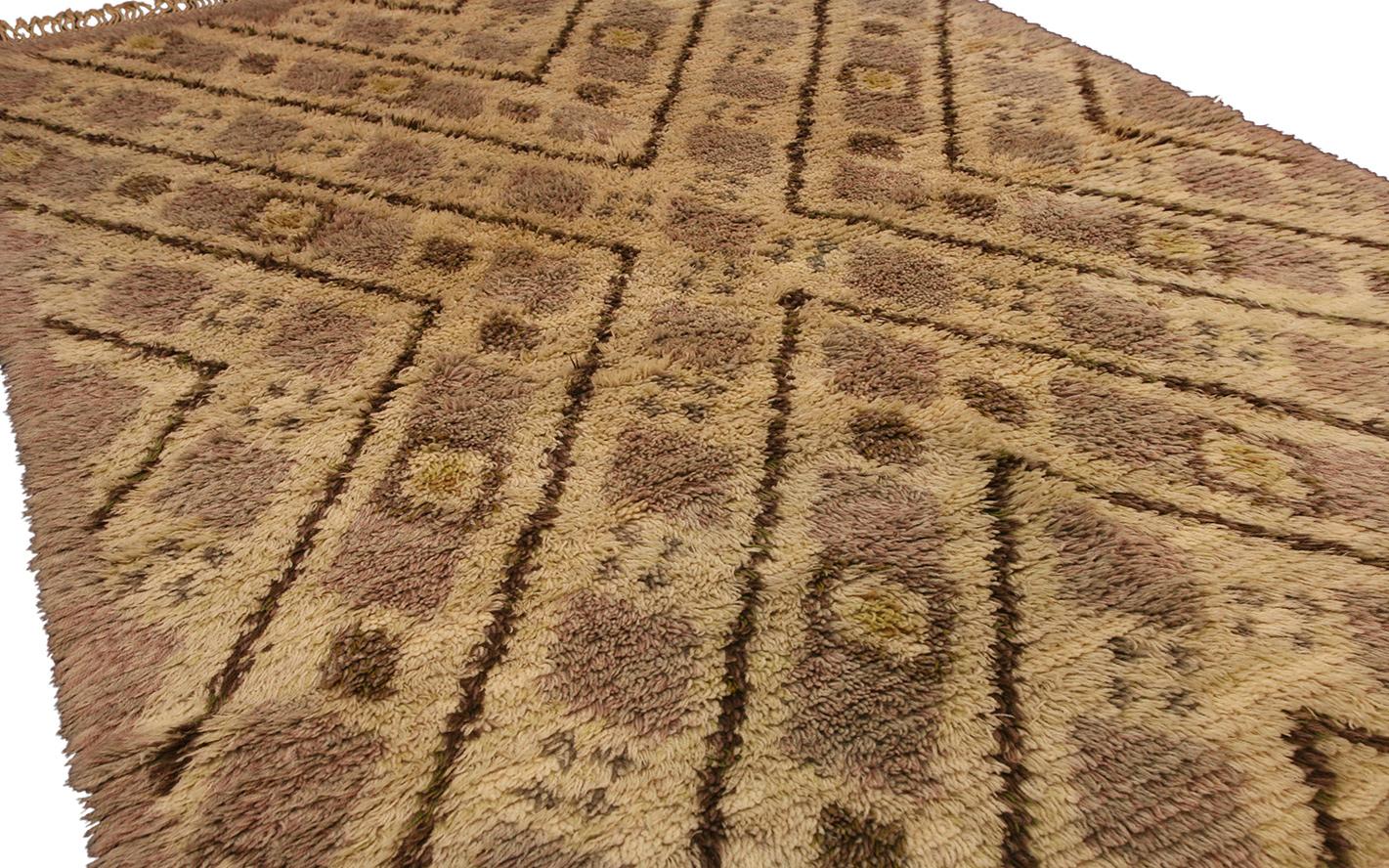 Questo tappeto Rya, che misura  140 x 215, presenta un design caldo e invitante caratterizzato da un pelo spesso e ispido e dai toni della terra. Il motivo geometrico a rombi in tonalità tenui aggiunge profondità e consistenza, rendendolo un pezzo
