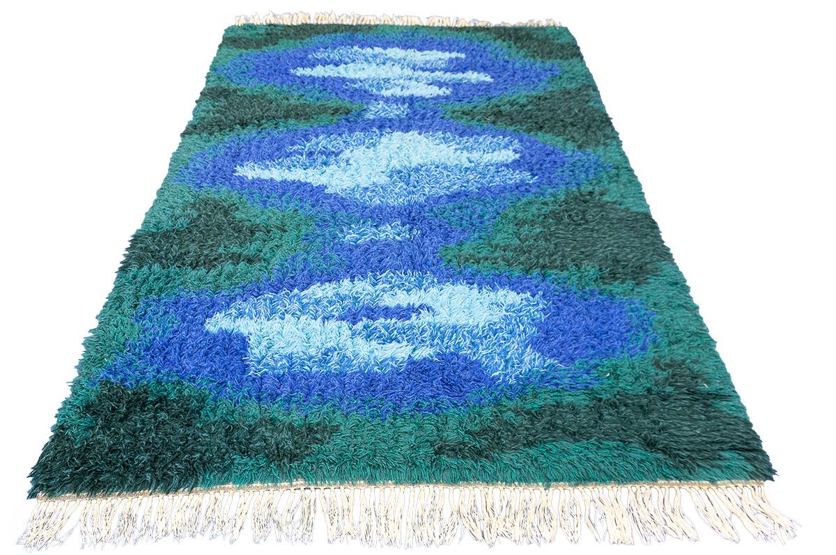 The Rya swedish rug is a remarkable piece of craftsmanship. Combining a simple yet eye-catching design, with the classic flat weaving technique, it's sure to make for an interesting addition to any home. The shades of blue and green provide a