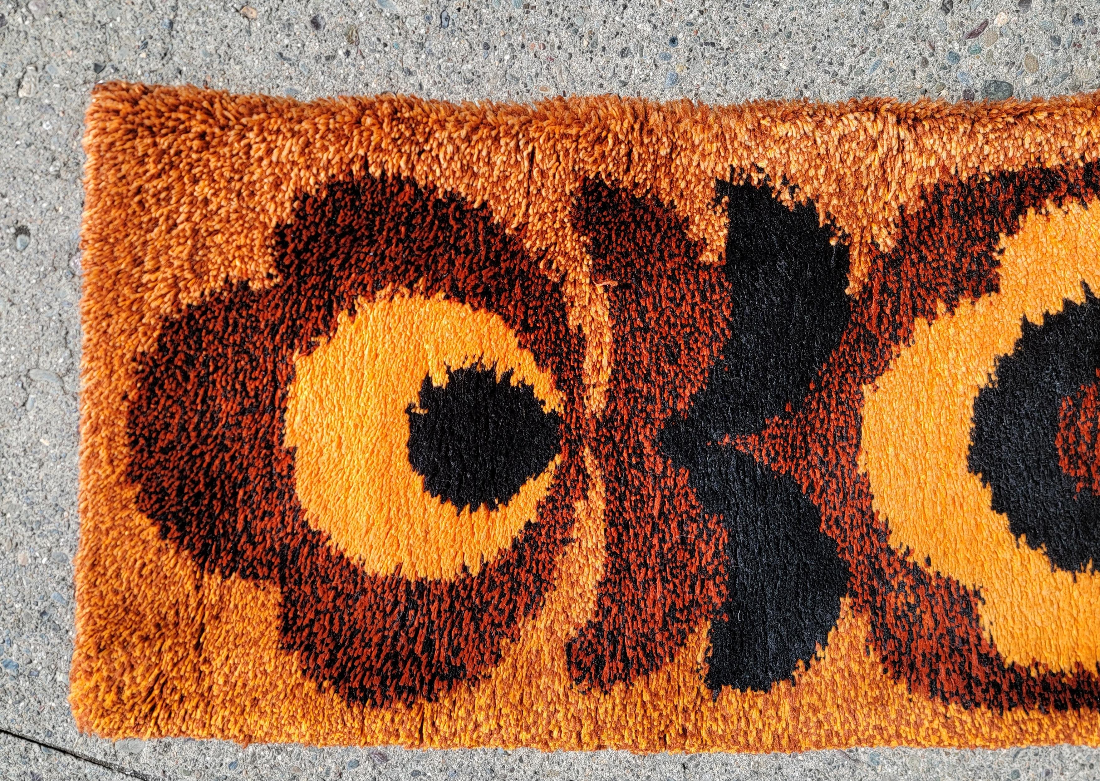 A Danish shag or Rya rug, circa. 1970's. Deep, rich shades of burnt orange with black accent. Has small brass circles attached to one side as this rug was once hung as a wall decoration. Hence, virtually no wear and no fading to colors.

Measures