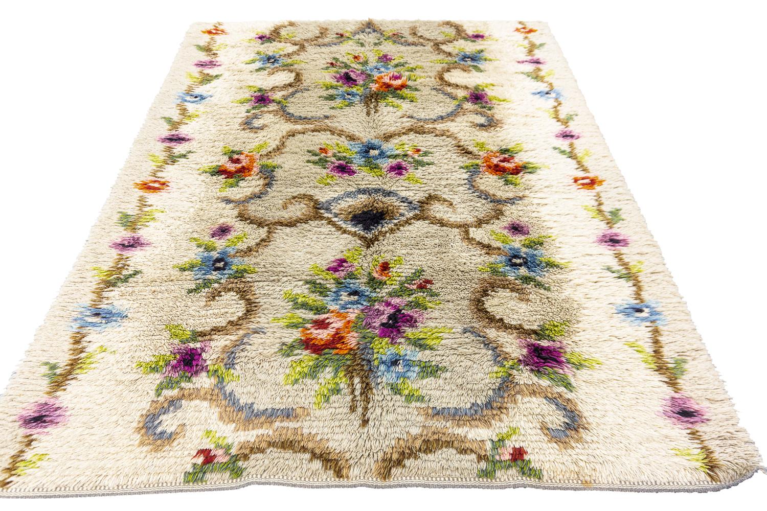 Il s'agit d'un tapis suédois vintage tissé au milieu du 20e siècle, entre 1950 et 1970, qui mesure 200 x 145 cm. Ce tapis présente un motif floral sur toute sa surface avec deux bouquets enfermés dans des crochets. Il présente des fleurs polychromes