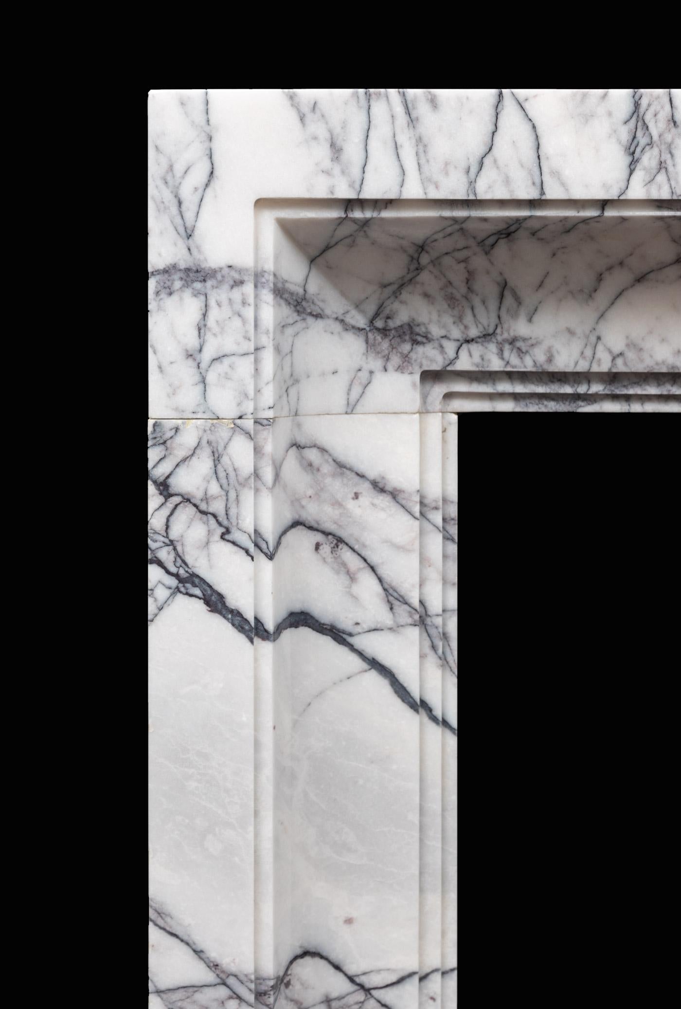 An Art Deco inspired fireplace surround made in strongly veined lilac marble. Produced in three solid blocks of carefully selected lilac marble, with vibrant markings that flow in the direction of the fireplace opening.