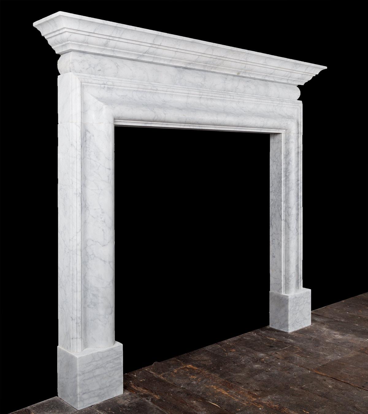 The fireplace has a molded bolection frame on plain plinths, above the frame rests a barrel shaped frieze and stepped cornice shelf. A classic design fashionable in Europe for over three hundred years.

 