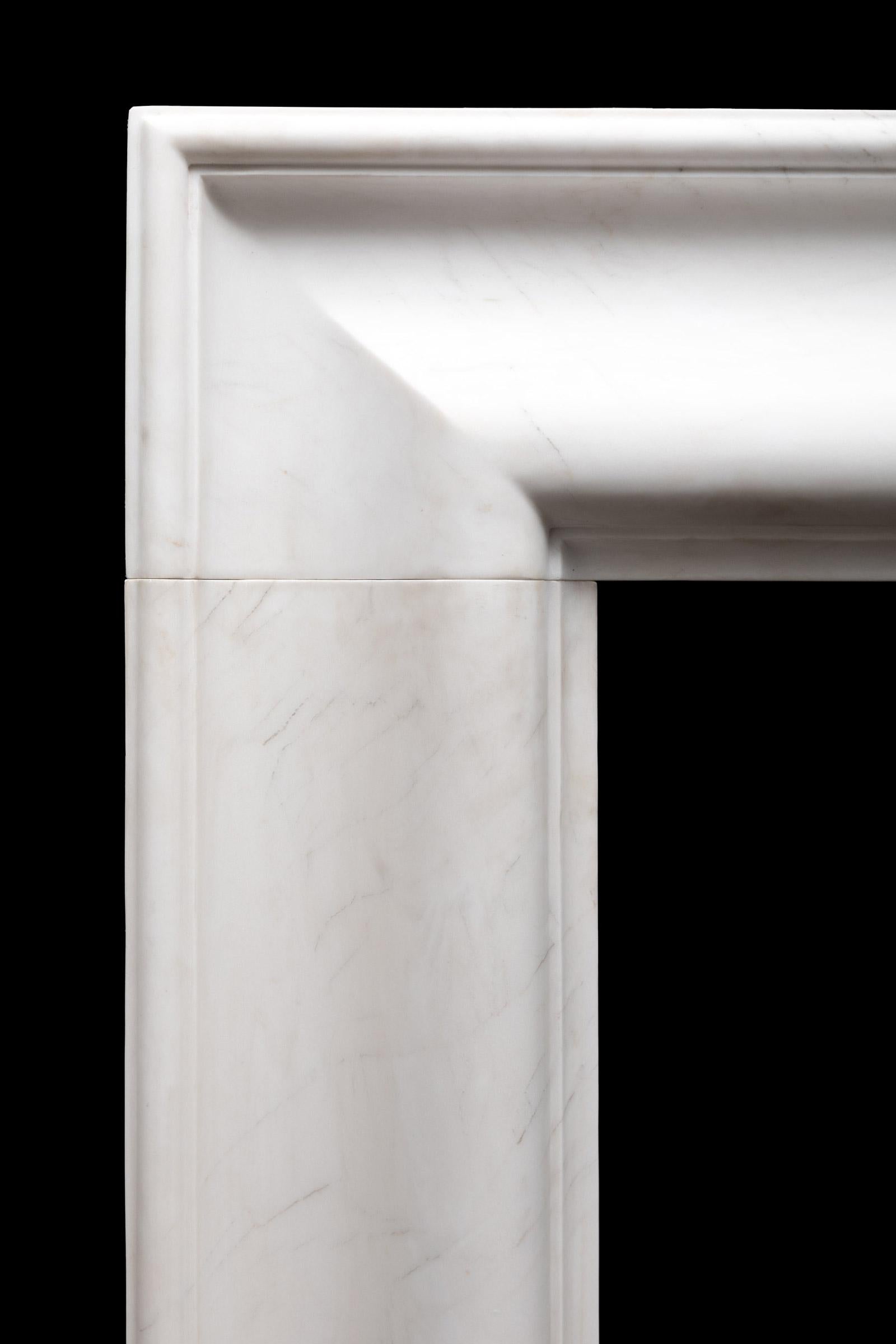 A large bolection fireplace produced in three solid blocks of white statuary marble with very subtle veining.
The Roma Bolection is a stylishly simple and robust example of a bolection moulding fireplace surround.