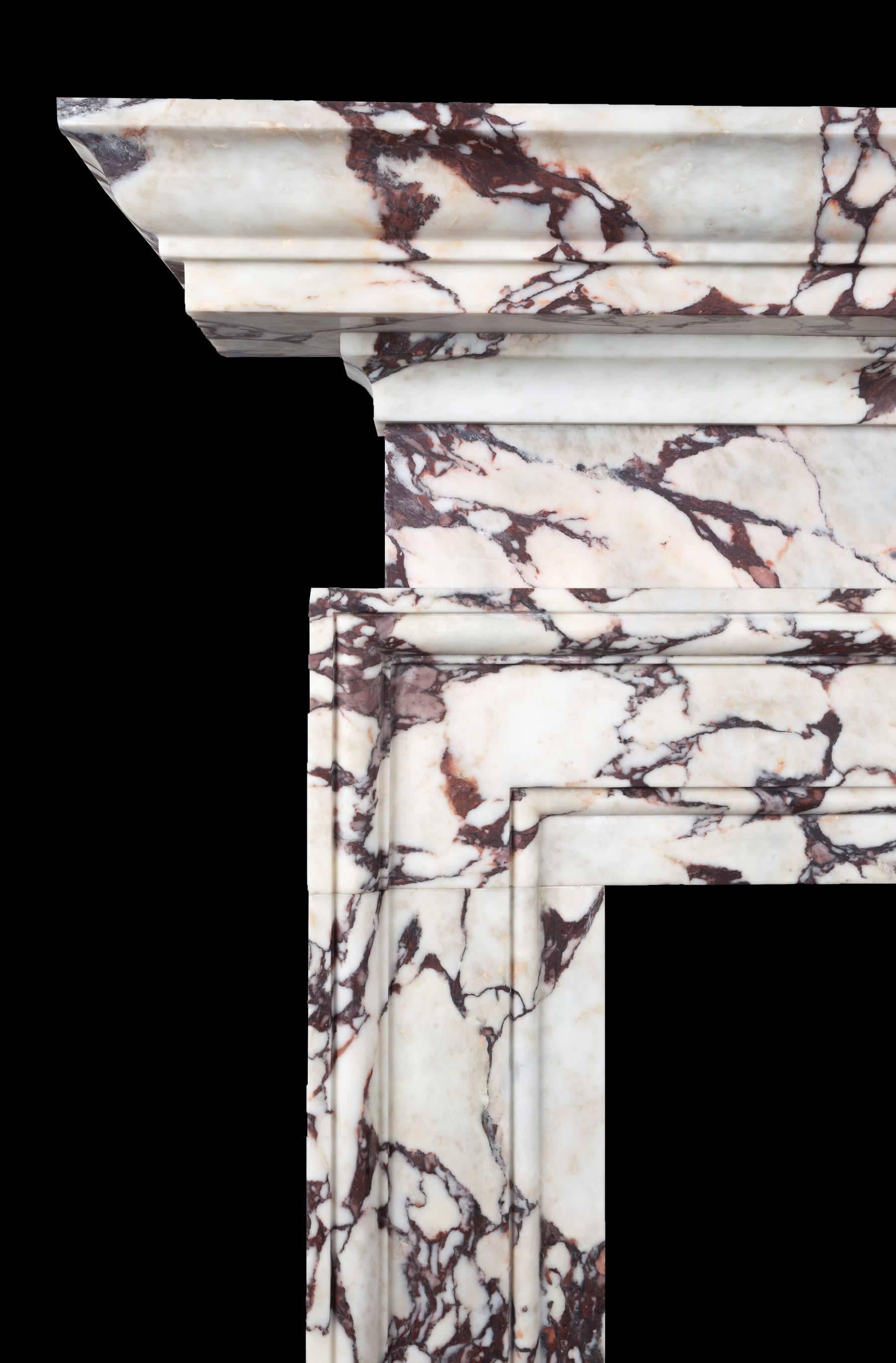 Ein Kamin aus Breccia-Viola-Marmor in stilvollem architektonischem Design. Die Öffnung ist von einem breiten Rahmen mit gestufter Leiste umgeben. Der schlichte und gedrungene Fries ergänzt den großzügigen und tiefen Sims des Kamins. Einer von fünf