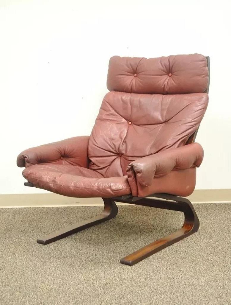 Rybo Rykken Mid Century Modern Rosewood Leather Kengu Lounge Chair and Ottoman. Item features bent rosewood bouncer floating frame, original red leather, upholstery, sleek Mid Century design. Circa Mid 20th Century. Measurements: Chair: 39
