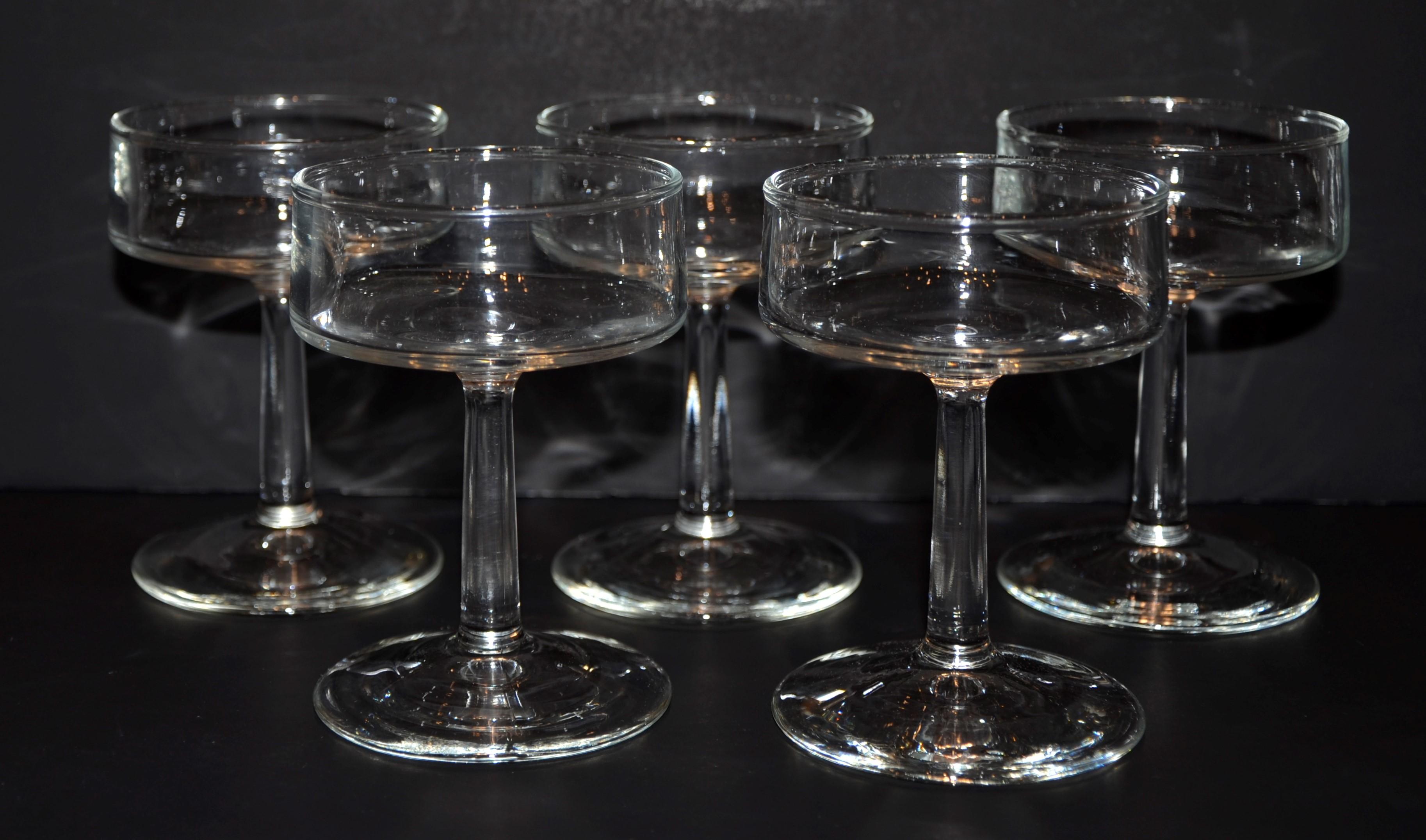 Offered is a set of five Mid-Century Modern petite glass champagne coupes and or sherbet bowls with stems. The size and design would indicate that the style of the champagne coupes are post Art Deco and early Mid-Century Modern. The glass champagne