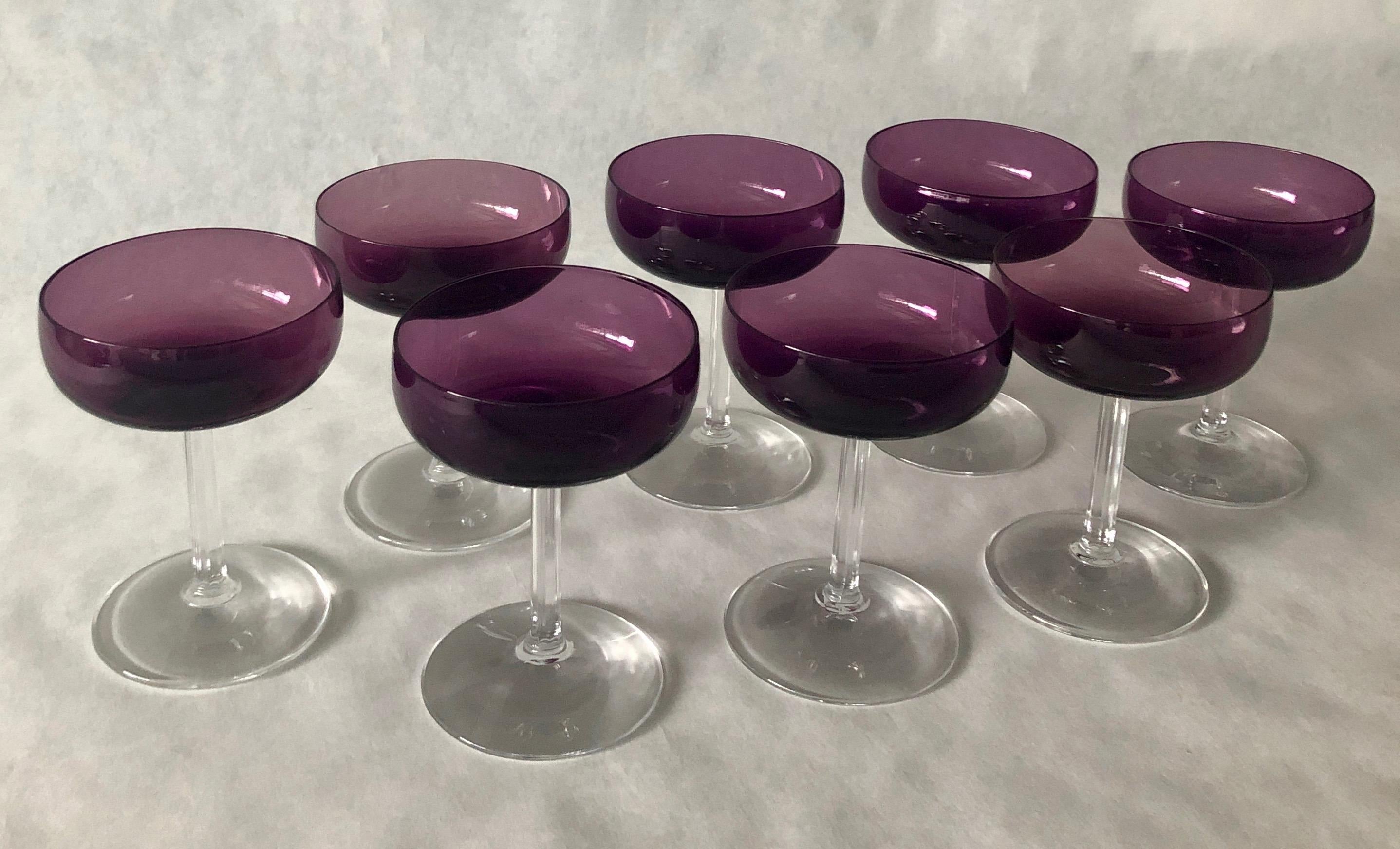 Offered is a set of eight champagne coupes in a luxurious translucent deep purple and clear stem by Fostoria that was retailed by the famed Houston luxury brand department store, Sakowitz. This set of champagne coupes are perfect for holiday