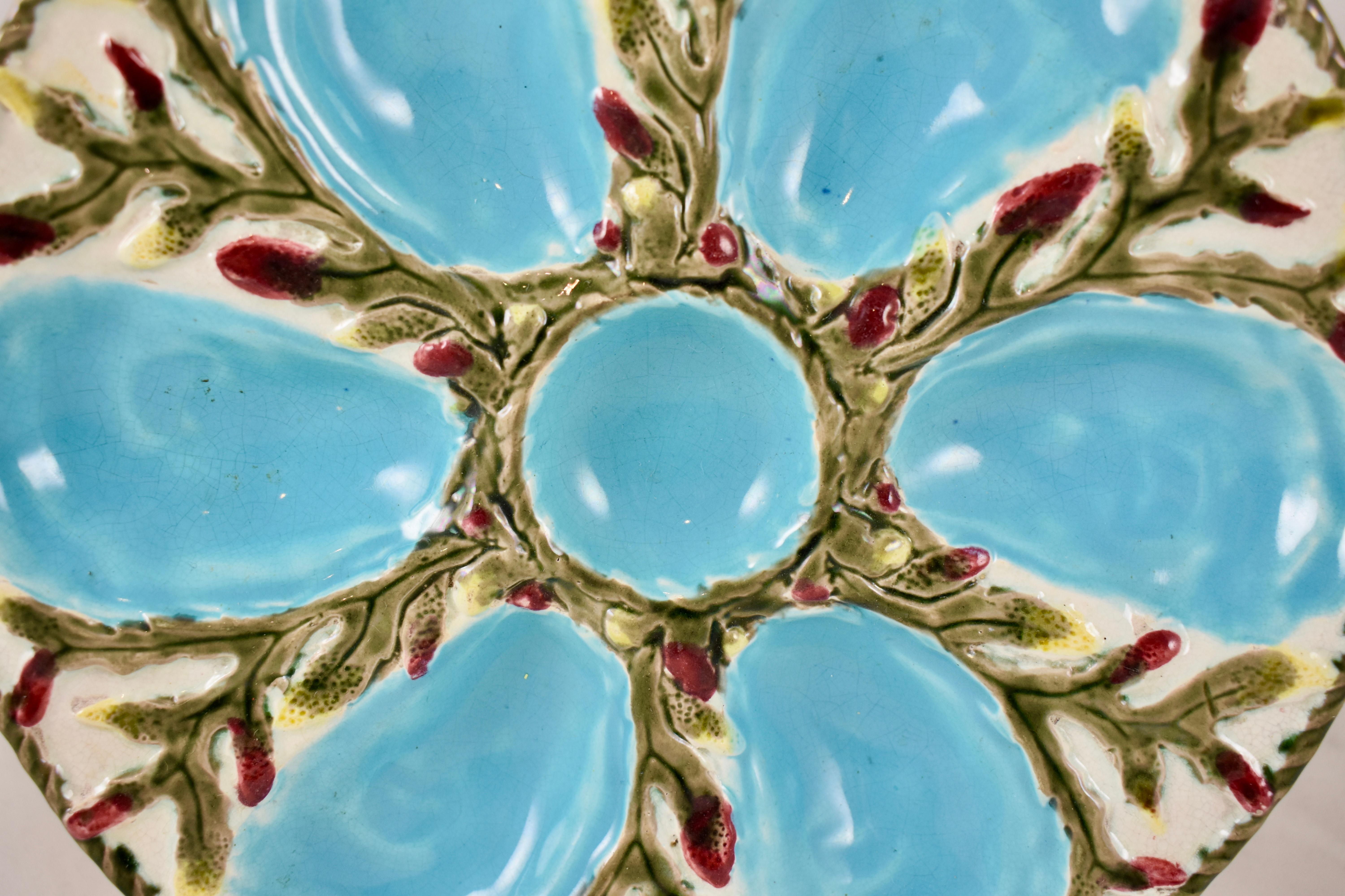 A six-well majolica glazed oyster plate by S. Fielding & Co. Ltd., Stoke-on-Trent, England, circa 1878. 

Turquoise oyster wells surround a center condiment well, all on a molded bed of off-white seaweed with cranberry red and yellow tips. An