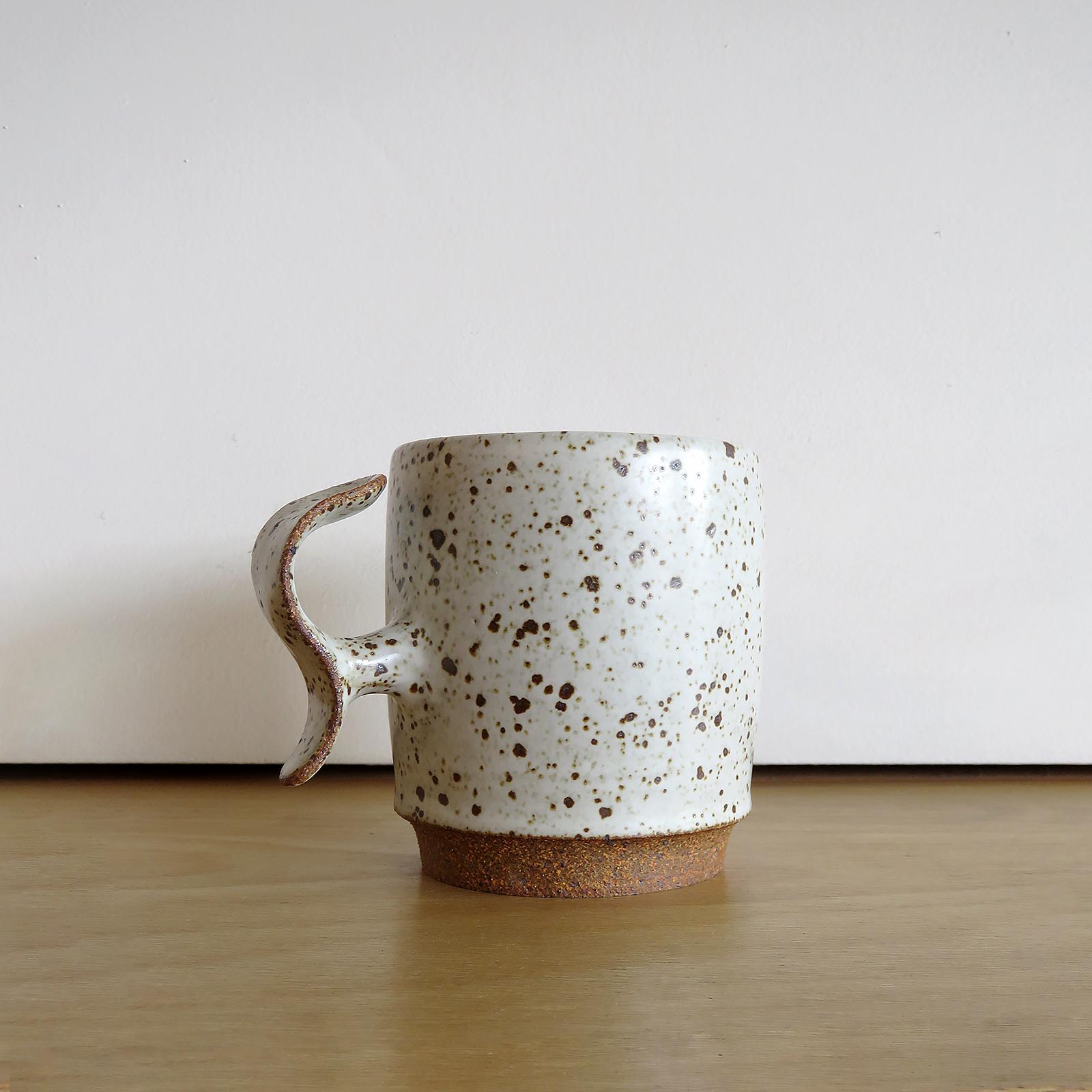 meravigliose tazze con impugnatura a S, realizzate a mano dal ceramista di Los Angeles Jed Farlow per Farlow Design. Gres ad alta cottura con smalto maculato bianco opaco. Progettate con un approccio incentrato sull'uomo, queste tazze uniche nel