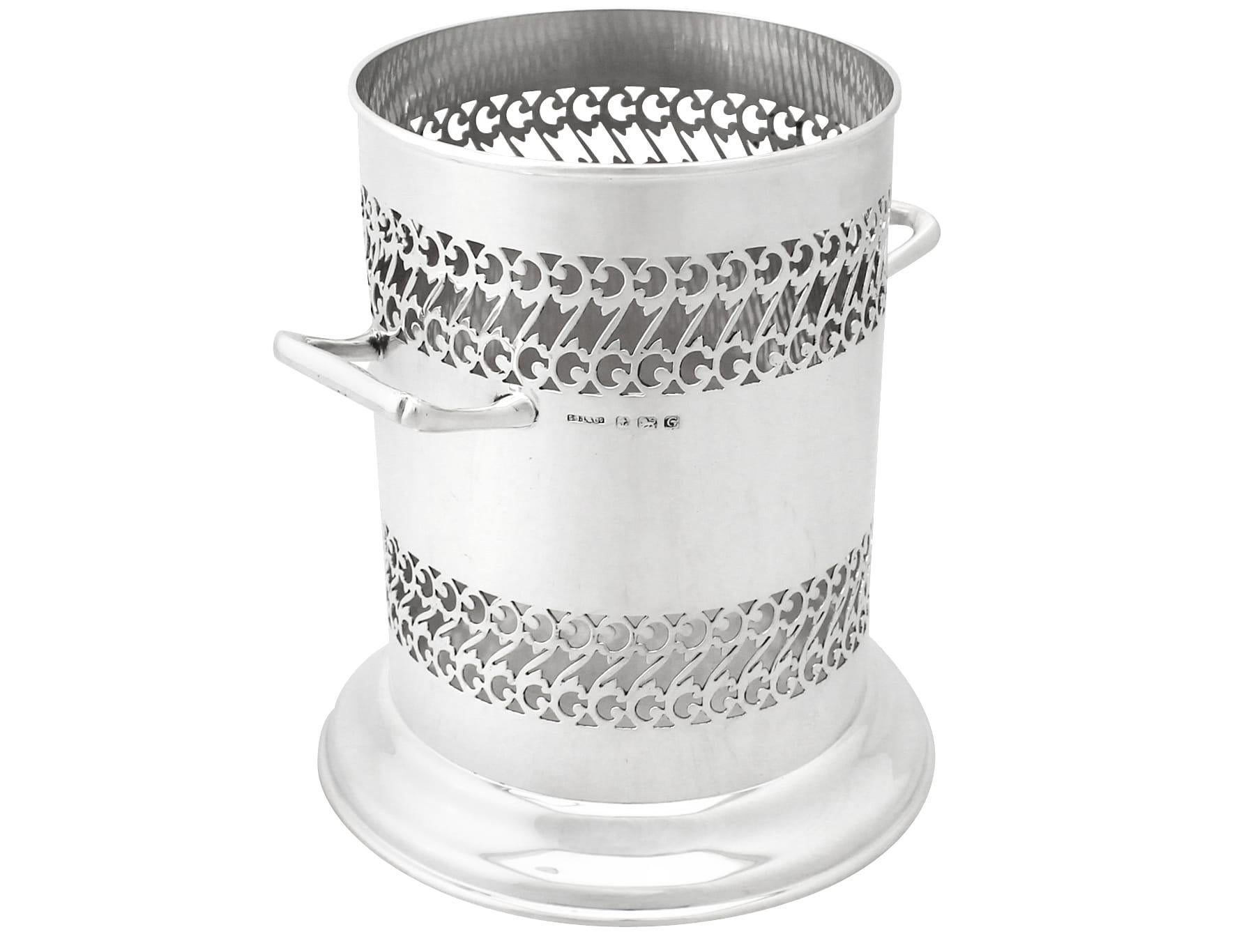 A fine and impressive antique George V English sterling silver bottle coaster, an addition to our ornamental silverware collection.

This impressive antique George V sterling silver bottle coaster has a plain cylindrical form to a domed spreading