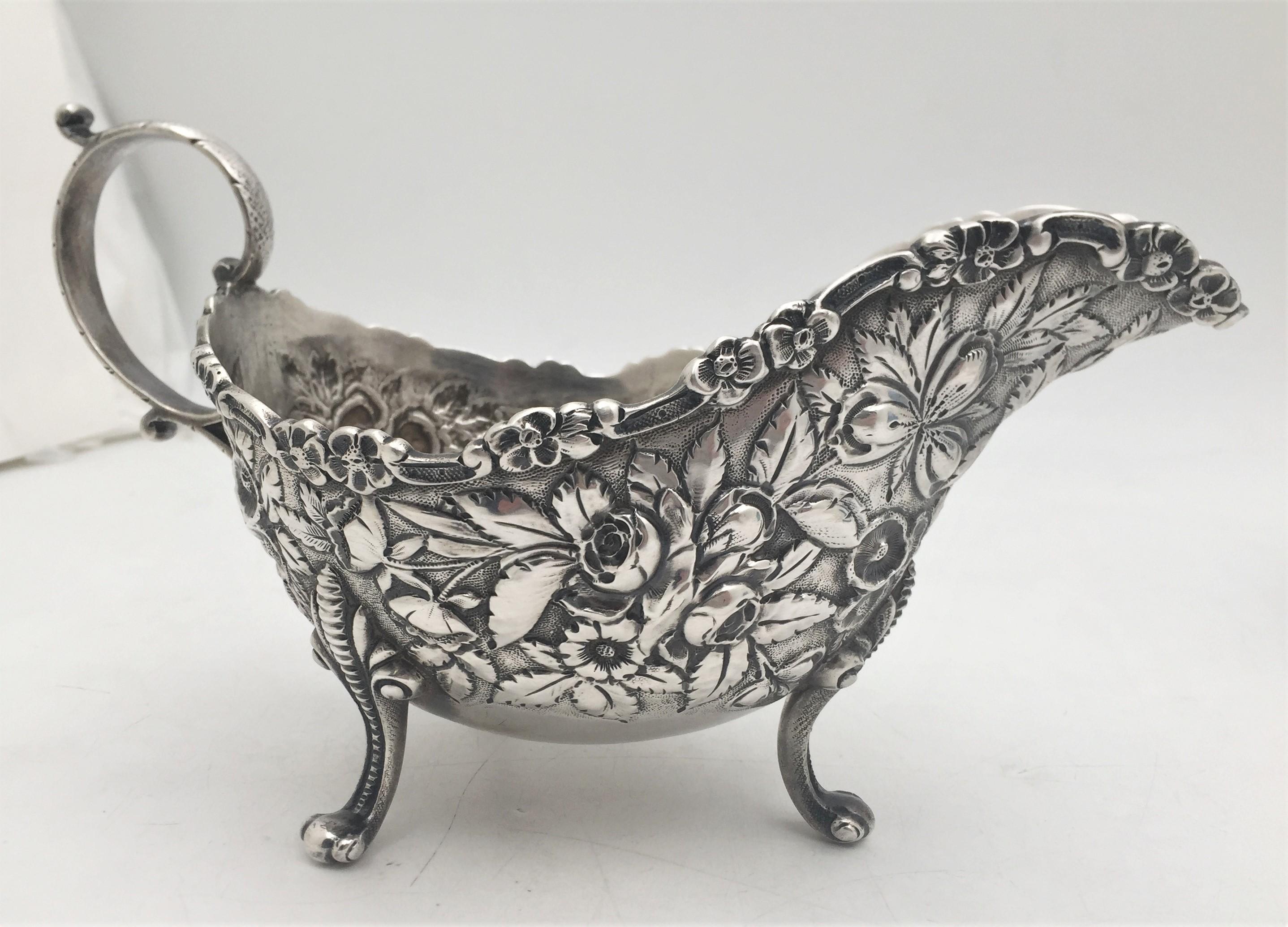 Set of two S. Kirk & Son, sterling silver sauce boats from the late 19th or early 20th century, in repousse pattern with exquisite, highly realistic, floral motifs, standing on 3 legs, with handles adorned with leaf motifs. Each measures 8 1/8''