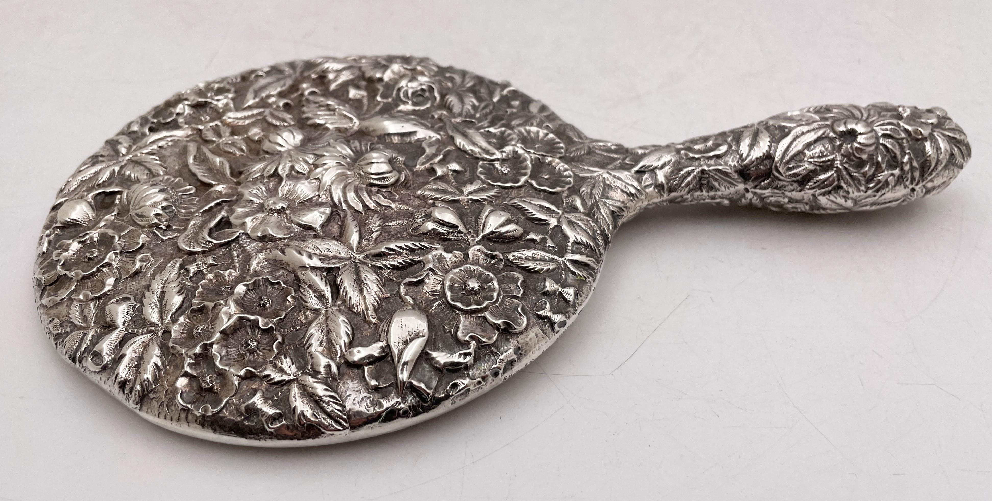 S. Kirk & Son, sterling silver and glass hand mirror from the 19th century, beautifully adorned with repousse floral motifs, measuring 9 3/4'' in length by in 5 7/8'' width by 5/8'' in depth, and bearing hallmarks as shown. 

Baltimore’s prominent