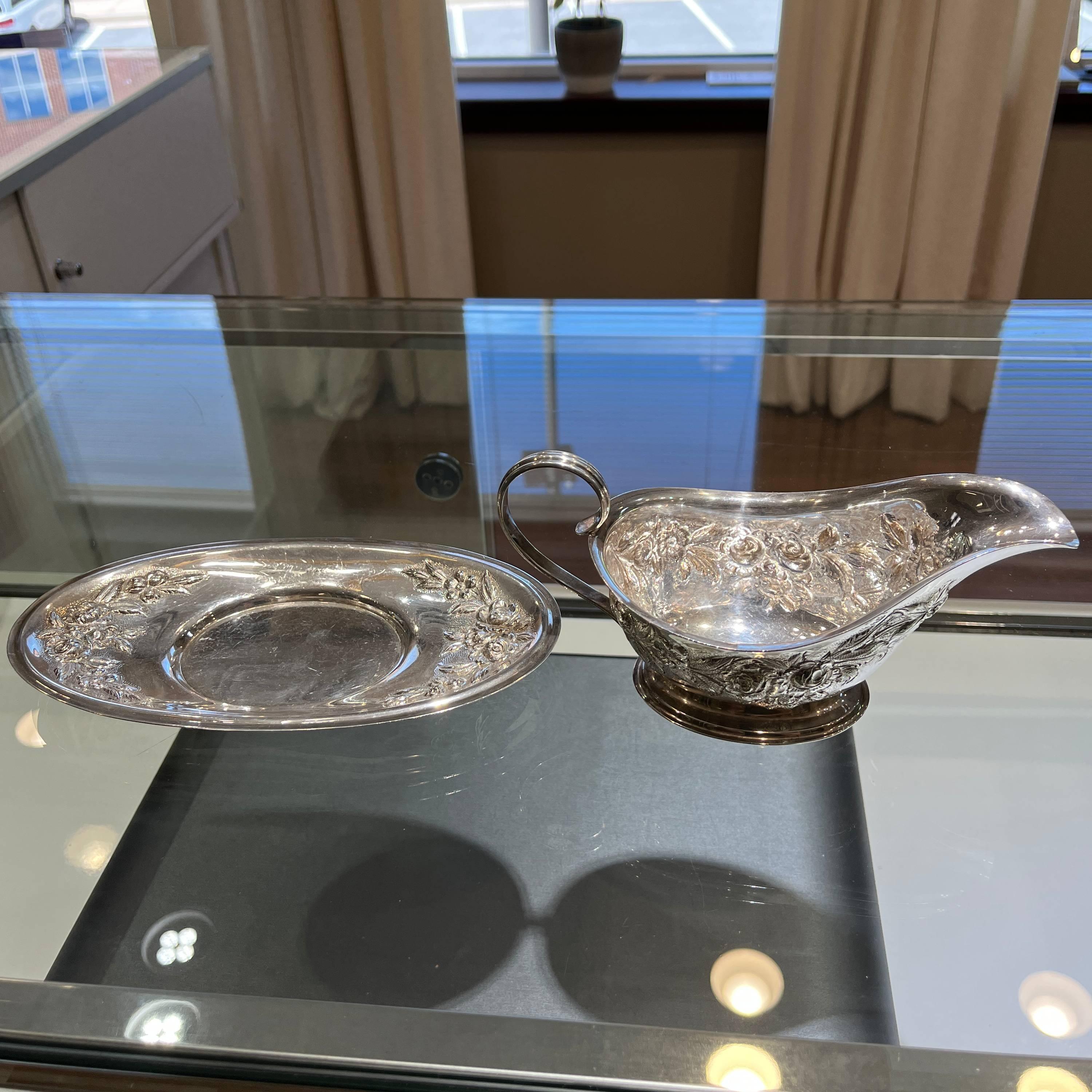 This beautiful sauce boat and underplate set is a must-have for any collector of sterling silver flatware. The intricate hand-decorated rose pattern adds a touch of elegance to any dining table. Crafted by S. Kirk & Son, this set is made of