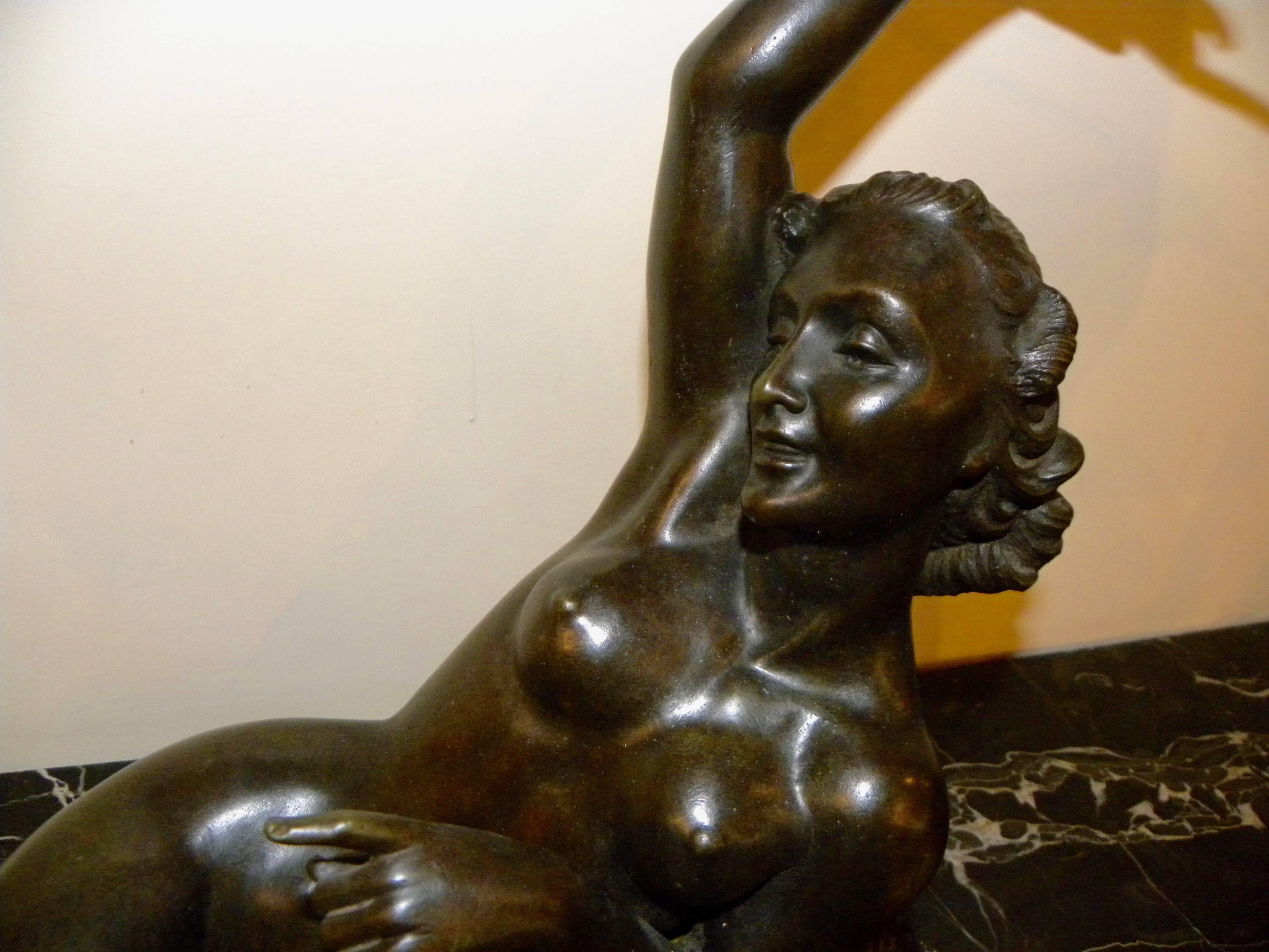 Sculpture en bronze de Salvatore Melani, de style Art déco, représentant un nu allongé, créée à la fin de sa carrière qui a commencé au début des années 1920 et s'est achevée en 1934, à l'âge de 32 ans. La pose sereine et sensuelle est définie par