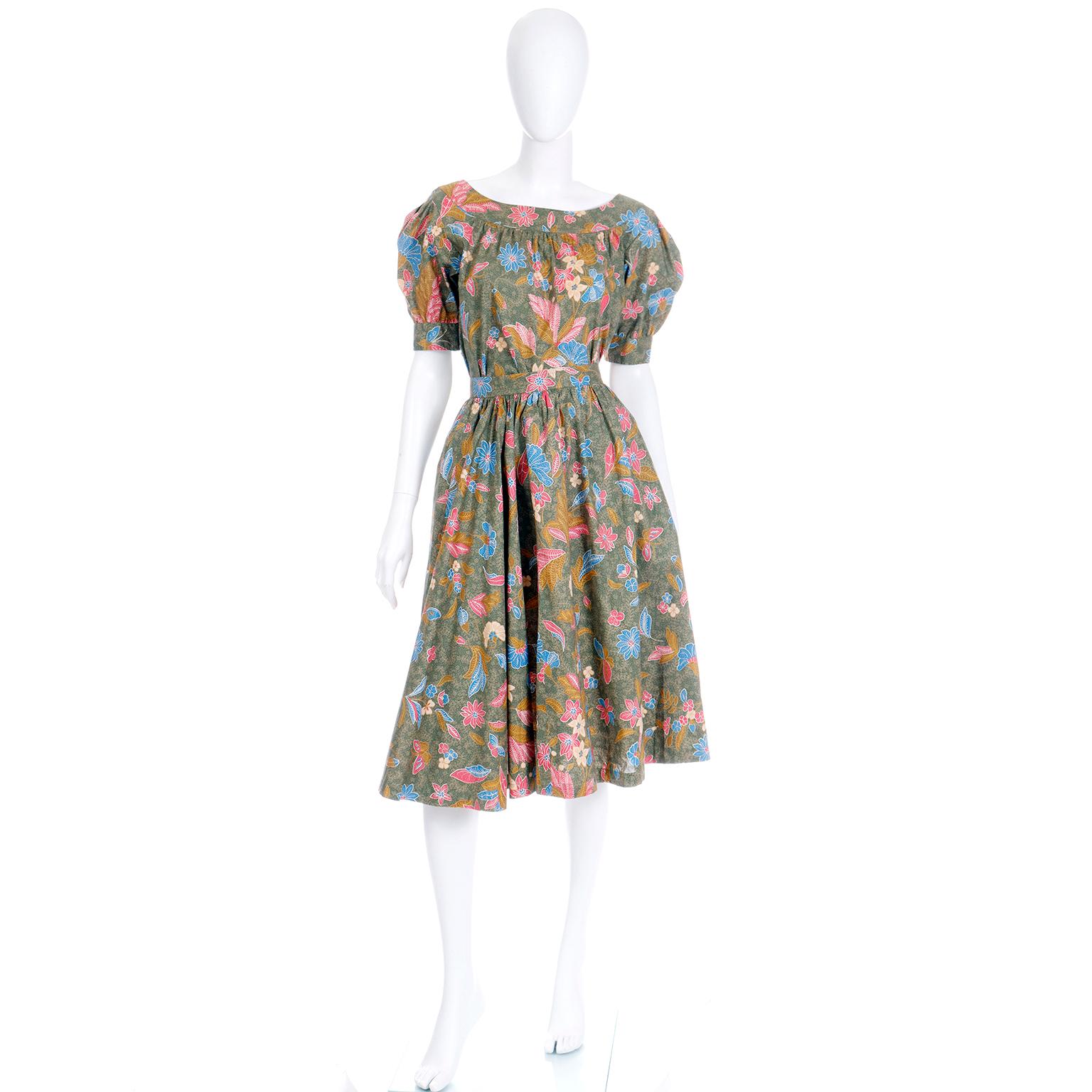 This is a gorgeous floral and butterfly print two piece day dress from the Yves Saint Laurent Spring/Summer 1986 collection. The matching top and skirt set look like a dress when worn together, but can be worn separately. It is olive green cotton,