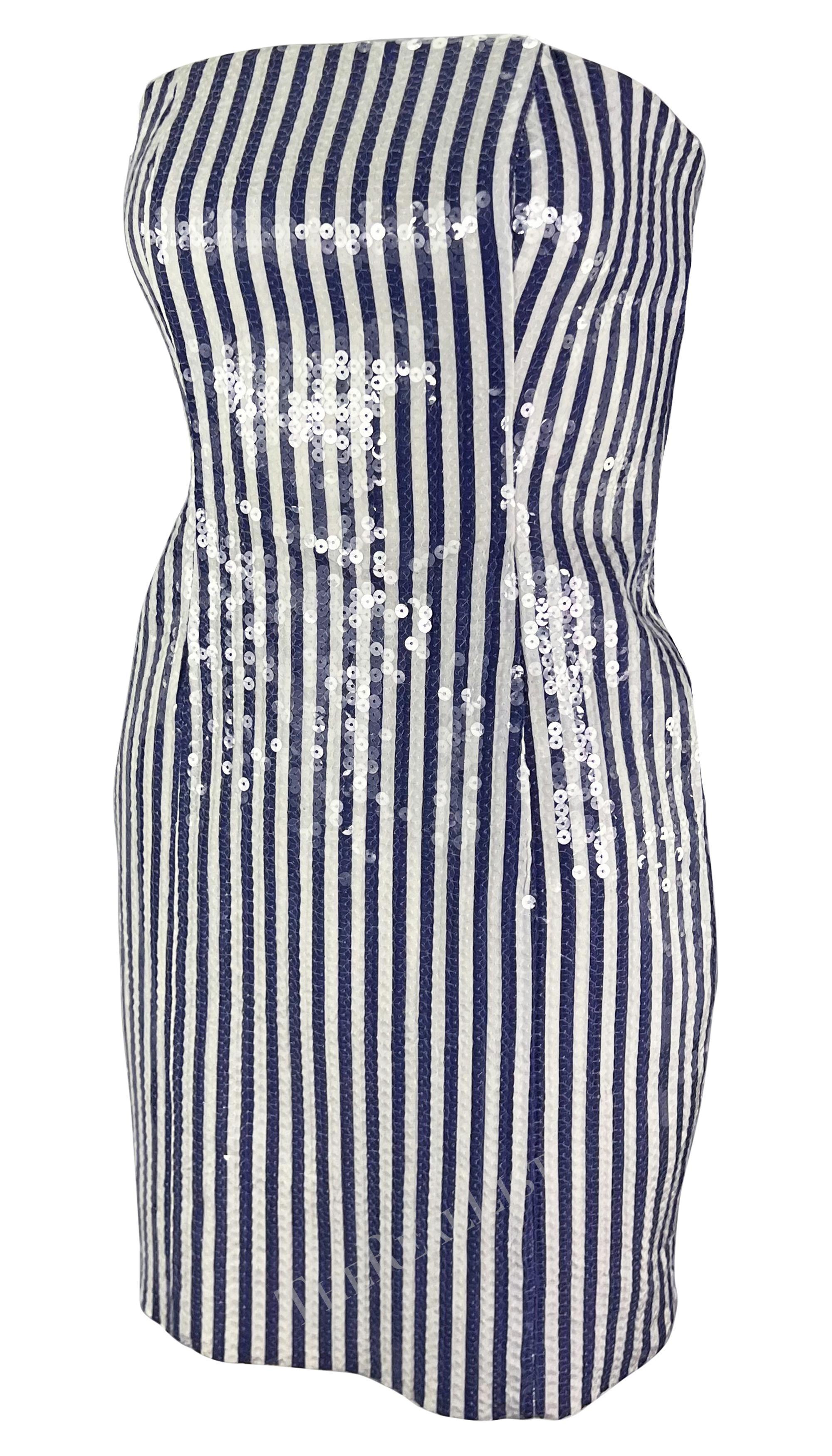 Sie präsentiert ein unglaubliches blau-weiß gestreiftes trägerloses Minikleid von Michael Kors. Eine fast identische Version dieses Minikleides aus der Frühjahr/Sommer-Kollektion 1990 wurde auf dem Laufsteg der Saison gezeigt. Das Kleid hat ein