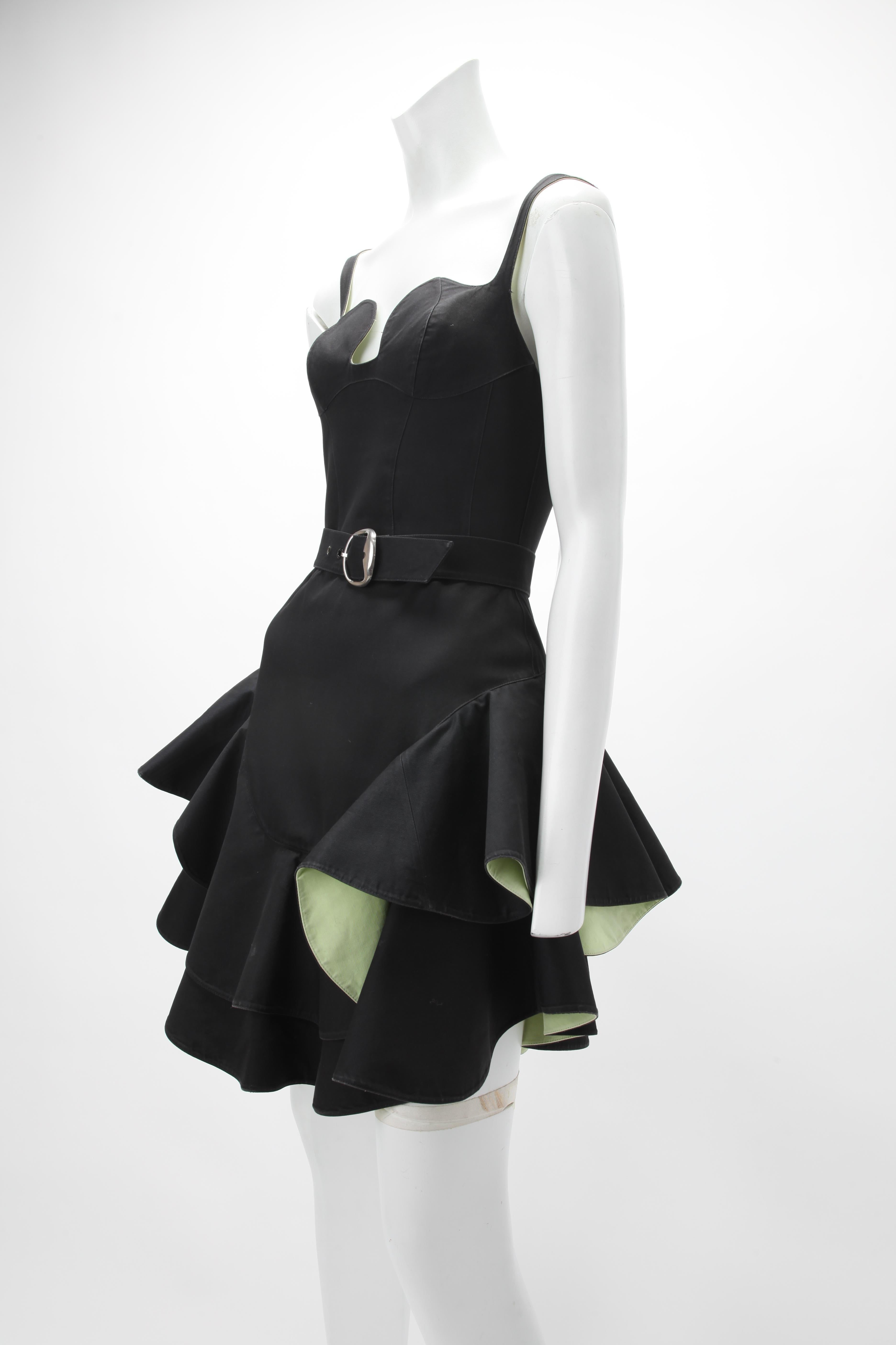 S/S 1990 Thierry Mugler Schwarzes Baumwollkleid mit mehrschichtigen, gestuften Rockteilen, die mit säuregrüner Baumwolle unterlegt sind; tailliertes Oberteil mit verstellbaren Trägern; eigener Gürtel mit silberfarbener Schnalle passend zu den