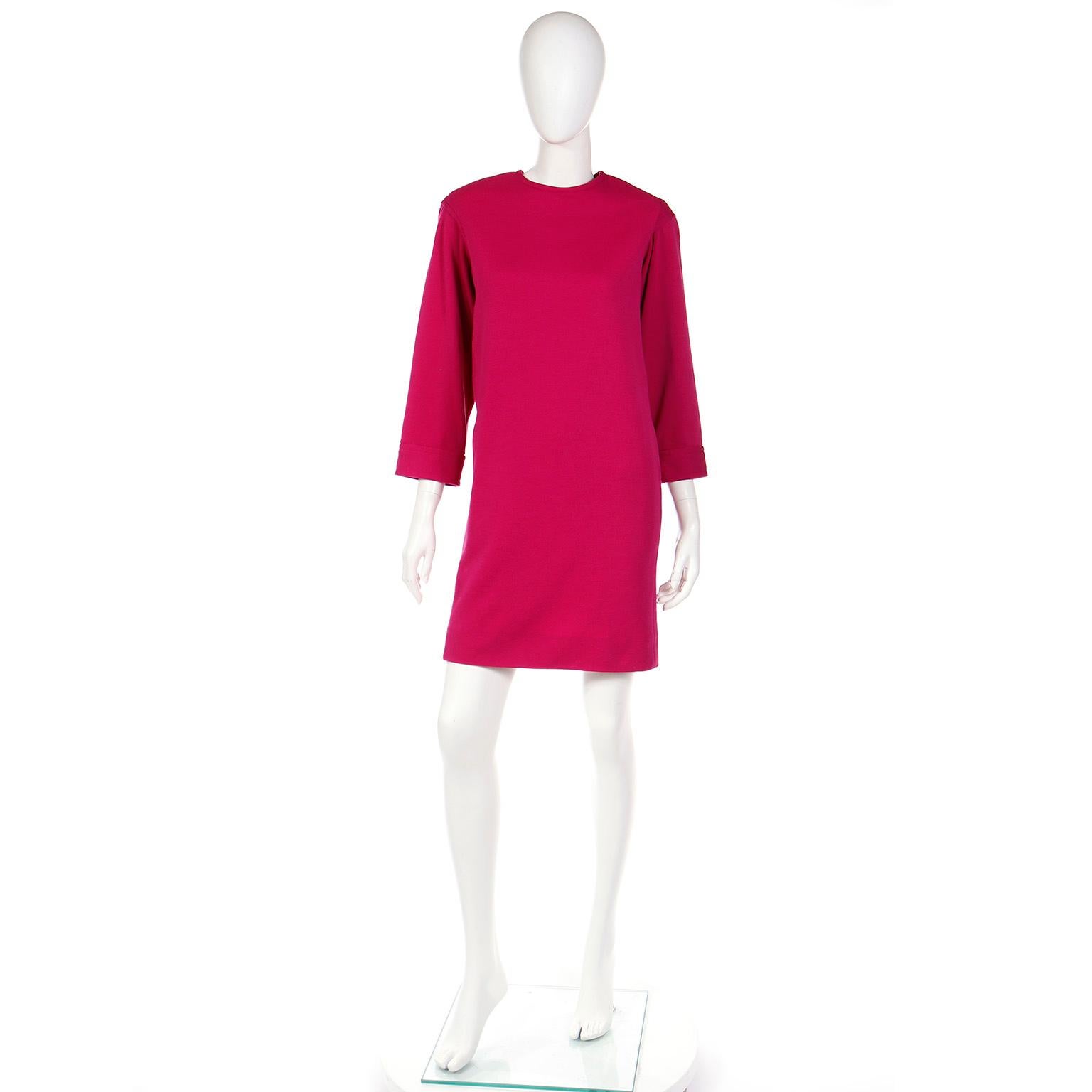 Dies ist ein Vintage Yves Saint Laurent Rive Gauche magenta rosa Wolle Etuikleid aus der Frühjahr / Sommer 1990 Kollektion. Dieses Kleid hat lange Ärmel und seitliche Schlitztaschen, mit eingearbeiteten Schulterpolstern für Struktur. Dieses