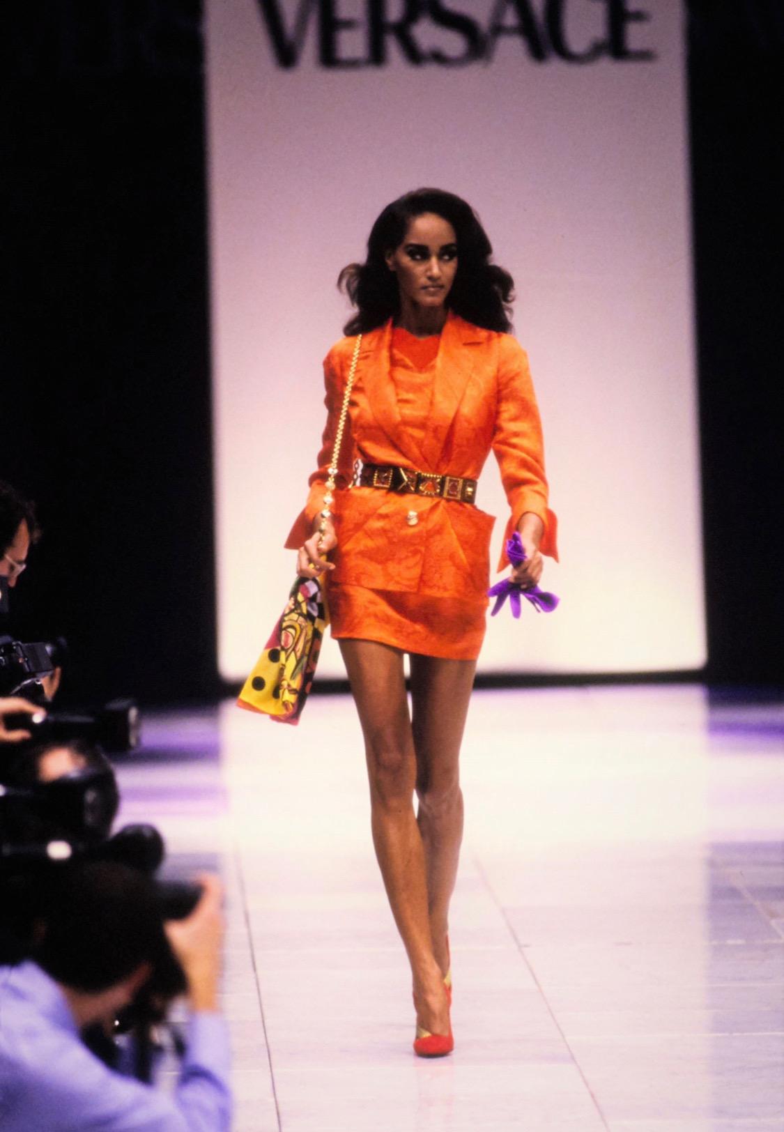TheRealList presents: a beautiful bright orange paisley silk Gianni Versace Couture blazer, designed by Gianni Versace. From the Spring/Summer 1991 collection this jacket debuted on the runway as look number 51. Featuring exaggerated pockets,
