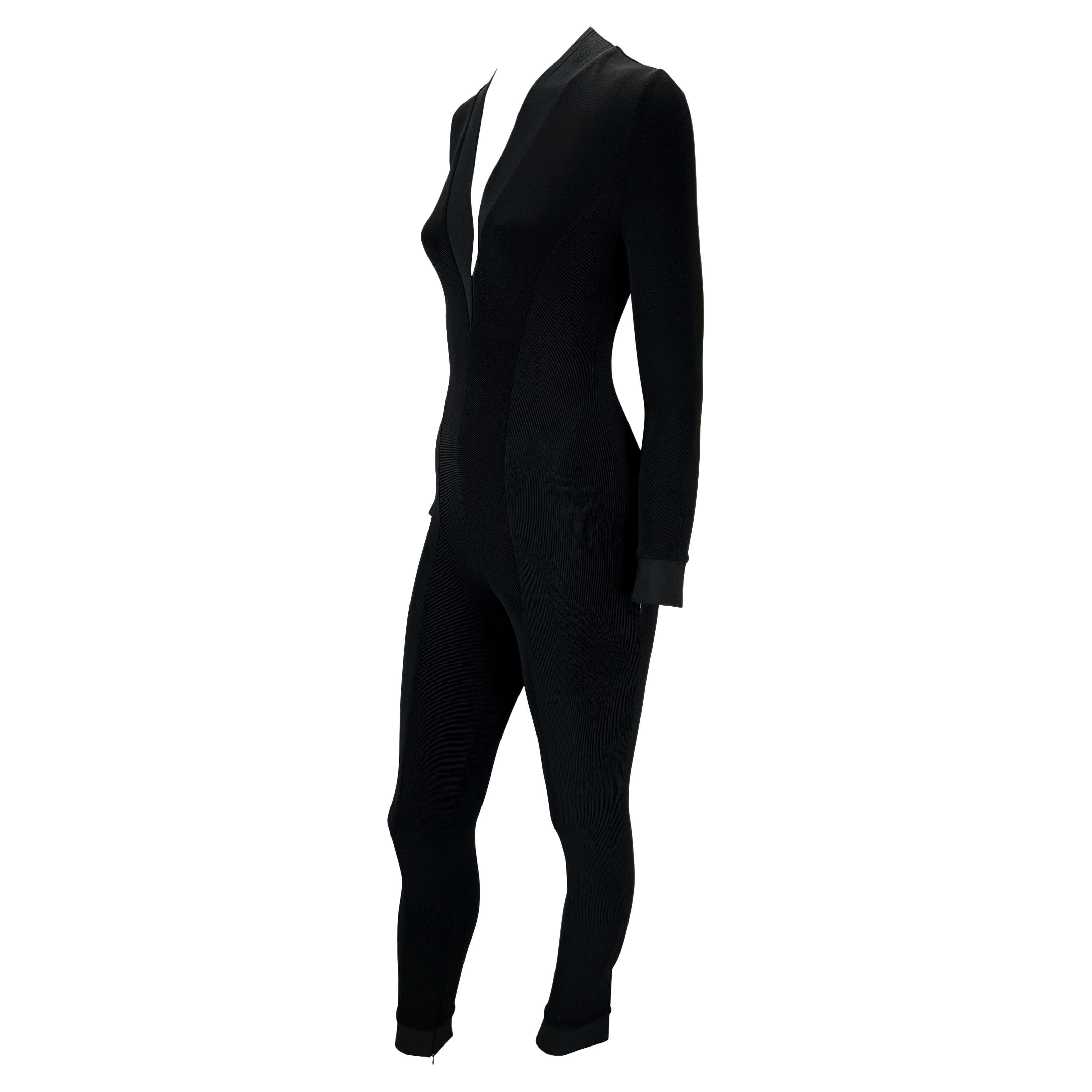 Presenting a gorgeous black ribbed Gianni Versace Couture catsuit, designed by Gianni Versace. From the Spring/Summer 1992 collection, this stunning catsuit features a plunging neckline, a stitched panel detail around the neckline, and full-length