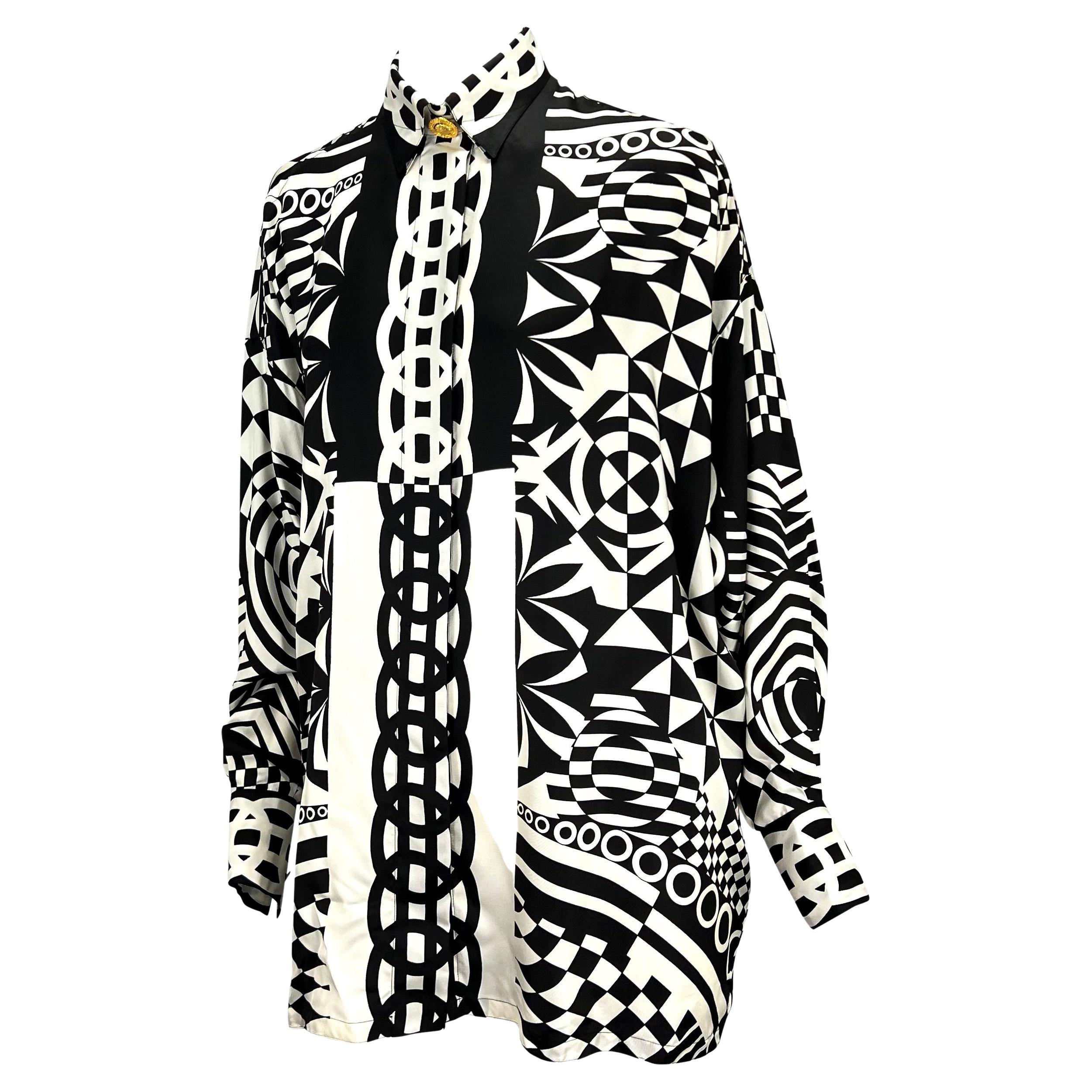 Wir präsentieren ein atemberaubendes monochromes Gianni Versace Couture Hemd aus Seide, entworfen von Gianni Versace. Dieses schwarz-weiße Seiden-Knopfleisten-Oberteil aus der Frühjahr/Sommer-Kollektion 1992 zeichnet sich durch geometrische,