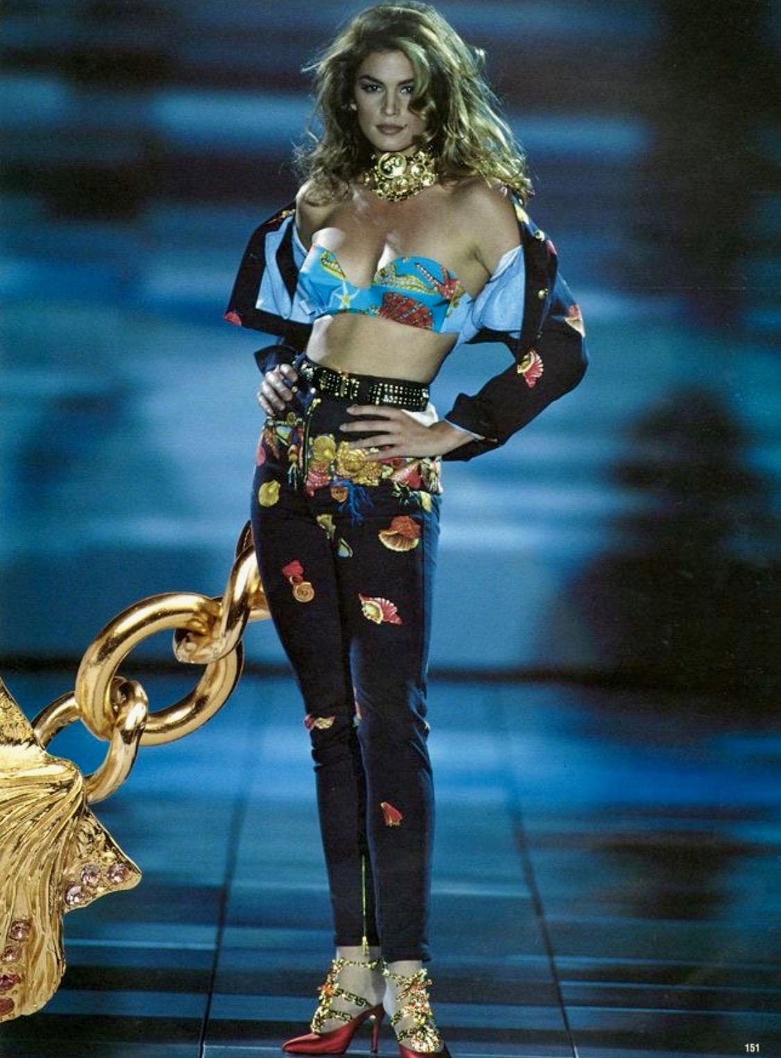 Presenting a flirty cropped denim jacket designed by Gianni Versace for his Spring/Summer 1992 collection. Debuting on look 42 on Cindy Crawford, this jacket features large golden Medusa button closures and two front pockets. Gianni elevated the
