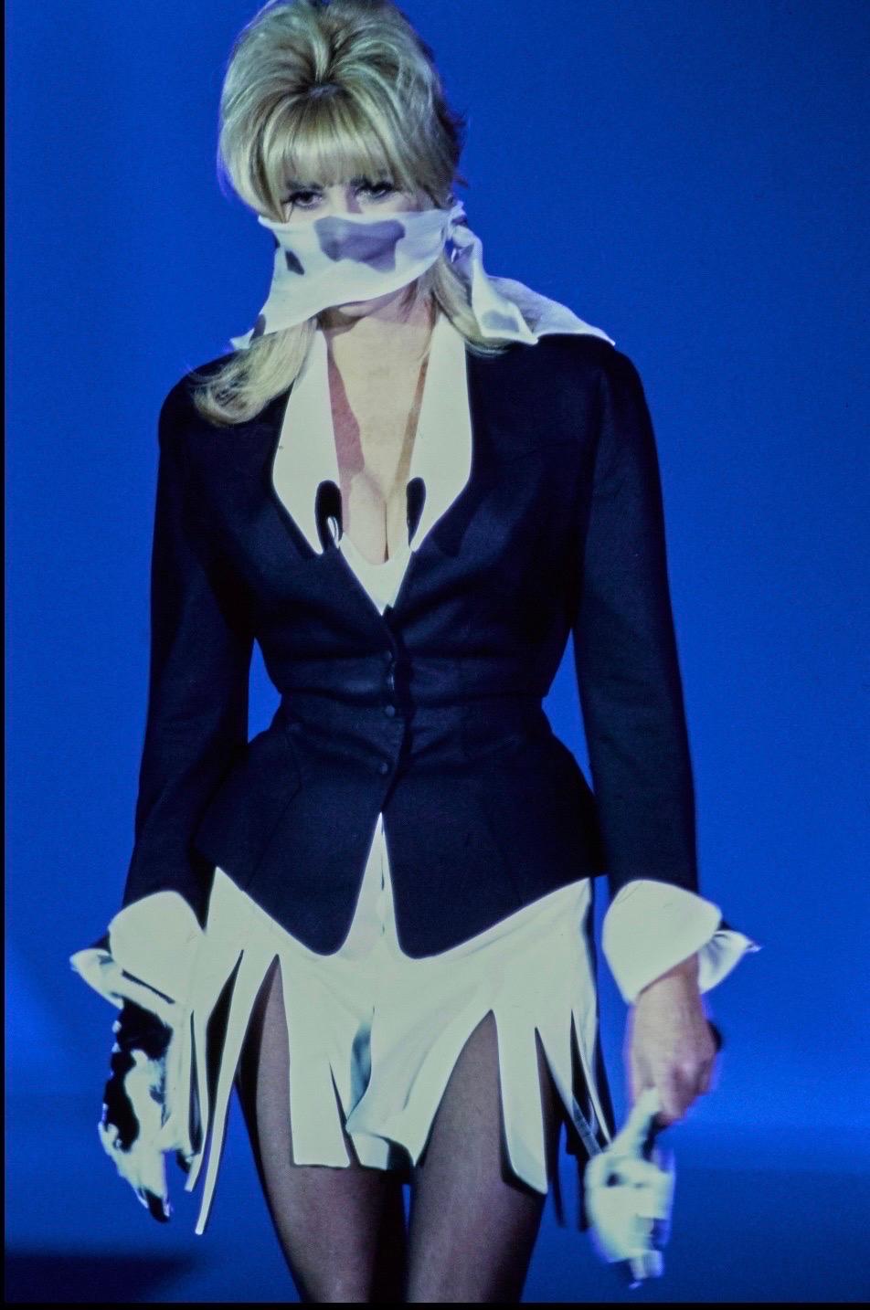Incredible rare Thierry Mugler black jacket with a dramatic pointed white collar and matching white cuffs from the Spring Summer 1992 collection and as seen on the runway.
Made in France
Fitted waist, pointed cuffs
Closes with two snap