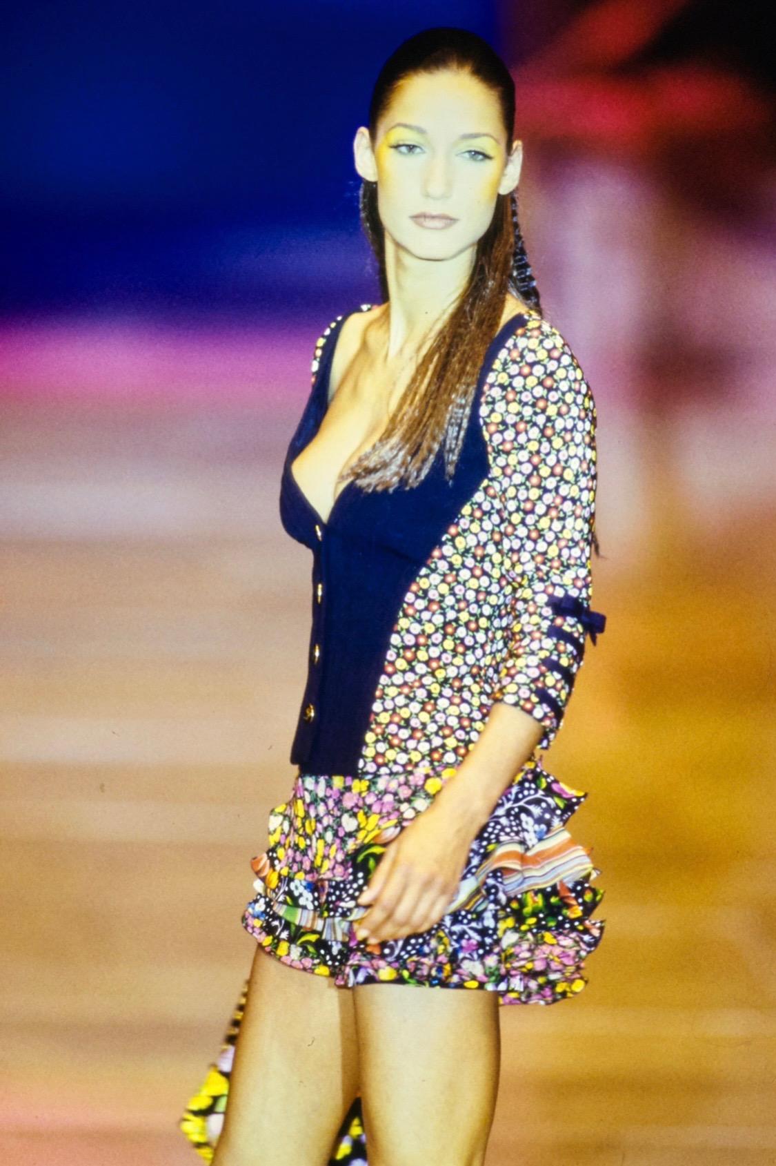 Ti presentiamo un paio di pantaloni floreali Gianni Versace Couture in denim nero, disegnati da Gianni Versace. Dalla collezione Primavera/Estate 1993, questi pantaloni a vita alta presentano un vivace motivo floreale e sono completati da rivetti