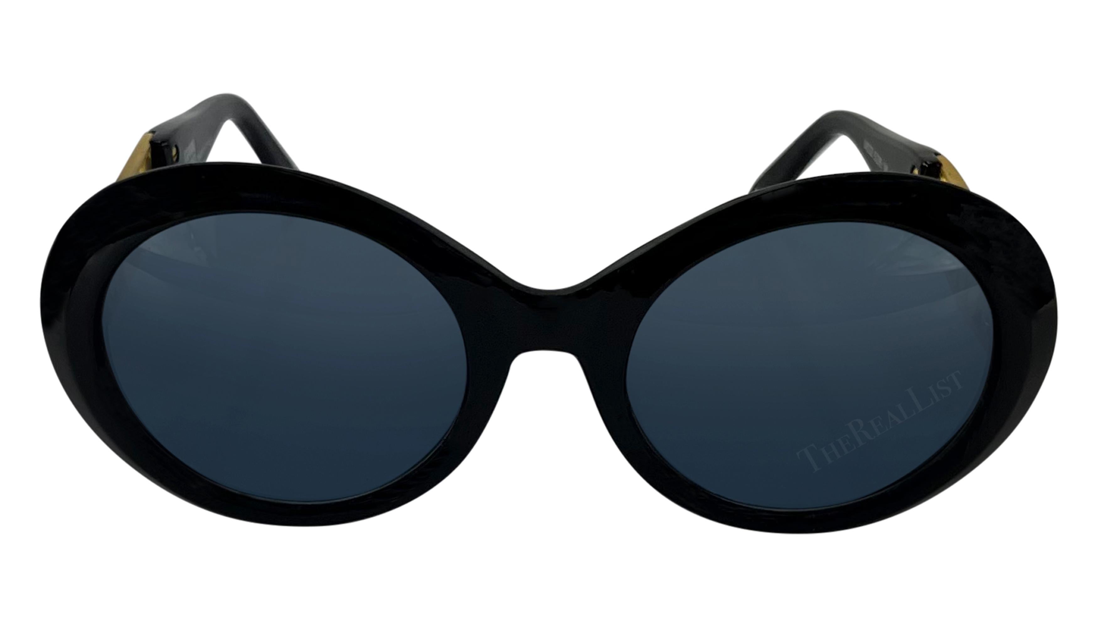 Ces lunettes de soleil rondes noires surdimensionnées, qui font partie de la collection printemps/été 1993, ont été conçues par Gianni Versace lui-même. Ornées des armoiries Miami en métal doré, elles rendent hommage à l'affection de Gianni pour