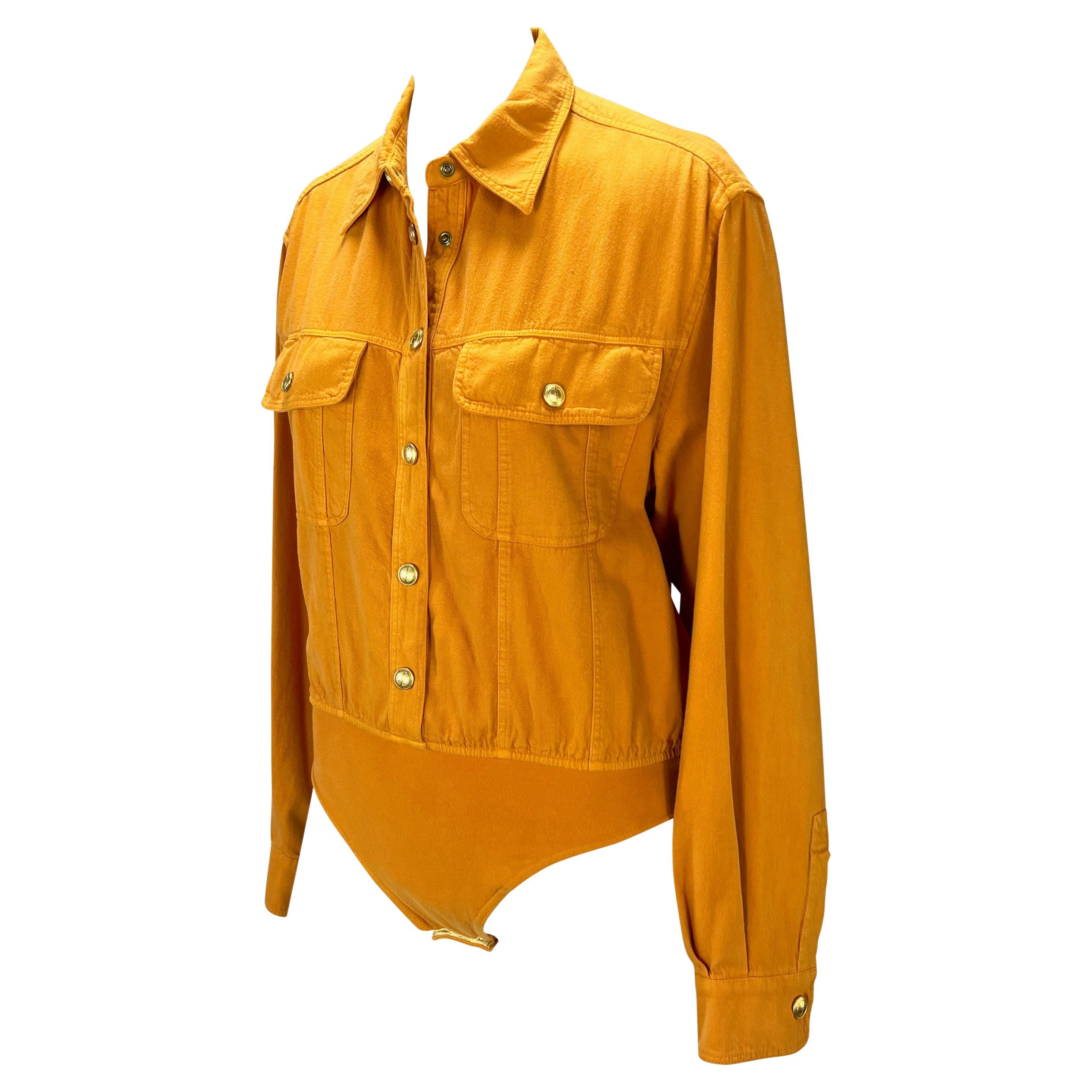 Wir präsentieren ein leuchtend orangefarbenes Gucci-Trikot. Dieses Oberteil aus der Frühjahr/Sommer-Kollektion 1993 ist ein klassisches Button-Down-Hemd mit zwei Brusttaschen und goldenen GG-Knopfverschlüssen. Das Oberteil verfügt über ein dehnbares