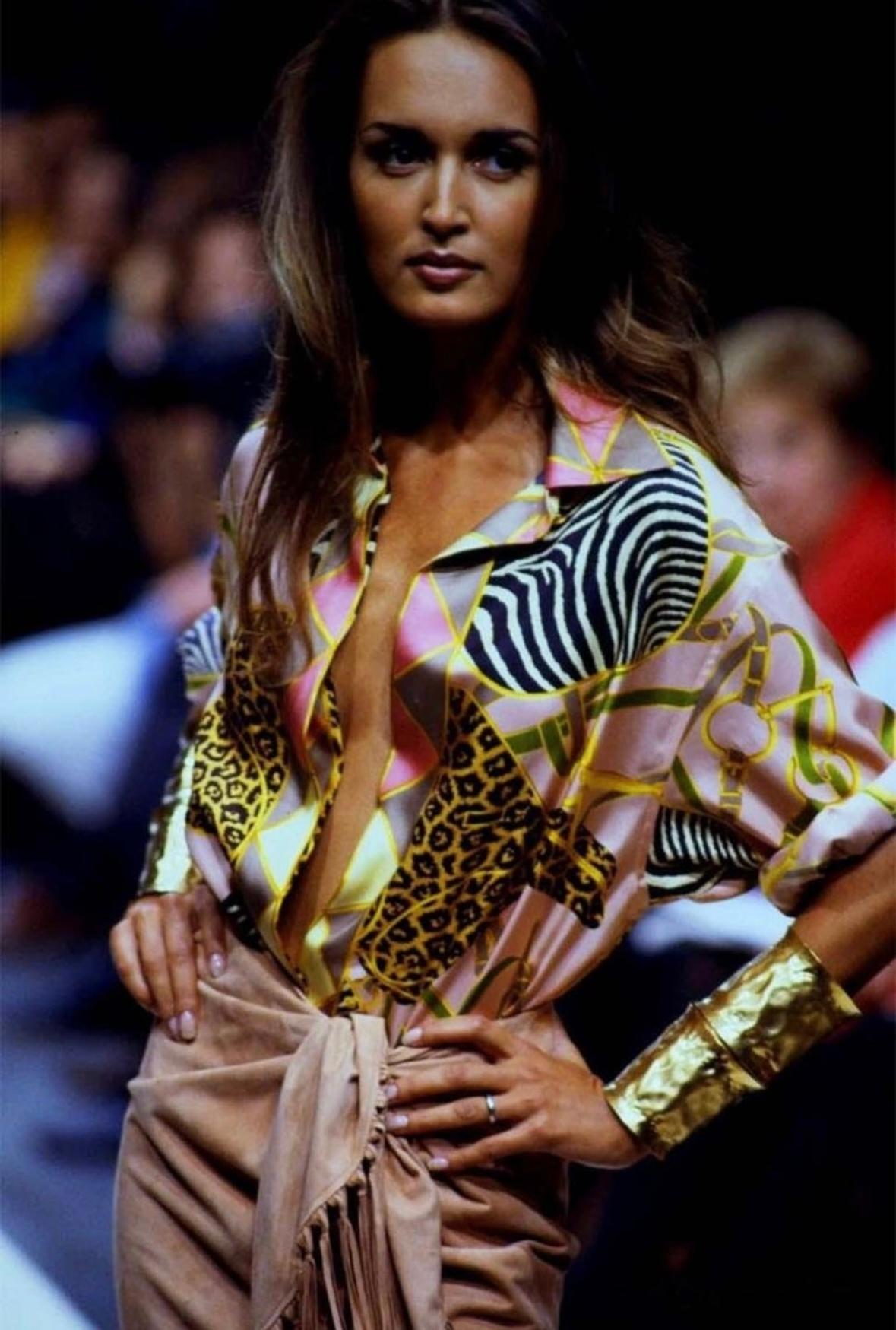 Wir präsentieren ein wunderschönes Gucci Seidenhemd mit Tierprint. Die rosafarbene Version dieses Oberteils aus der Frühjahr/Sommer-Kollektion 1993 wurde erstmals auf dem Laufsteg von Gail Elliott gezeigt. Das aus Seide gefertigte Kleidungsstück