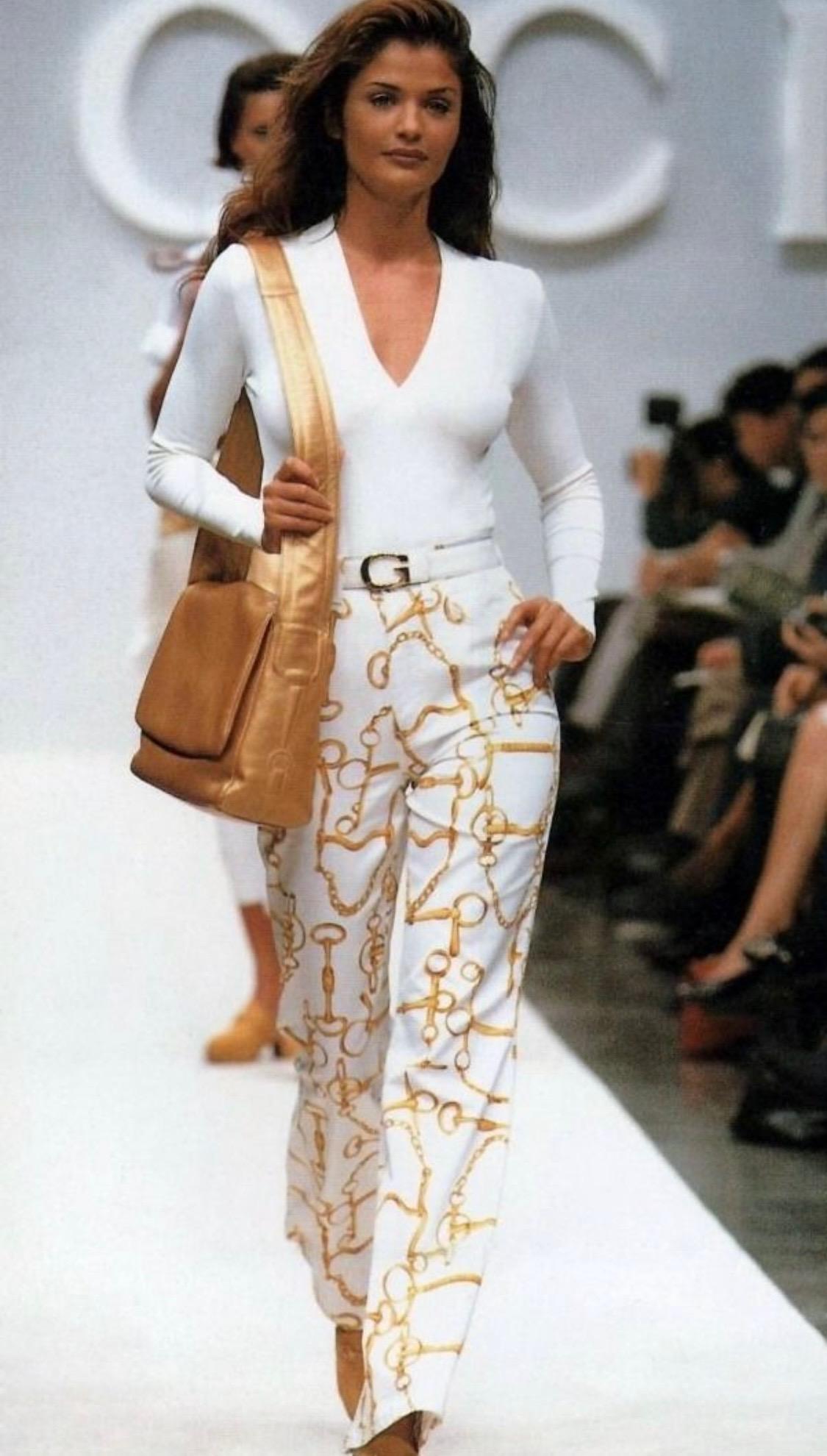 Ti presentiamo una camicia in seta di Gucci con motivo a catena a forma di morso di cavallo. Questa camicia con colletto in seta della collezione primavera/estate 1993 sfoggia il famoso motivo equestre di Gucci e presenta dei pezzetti di cavallo