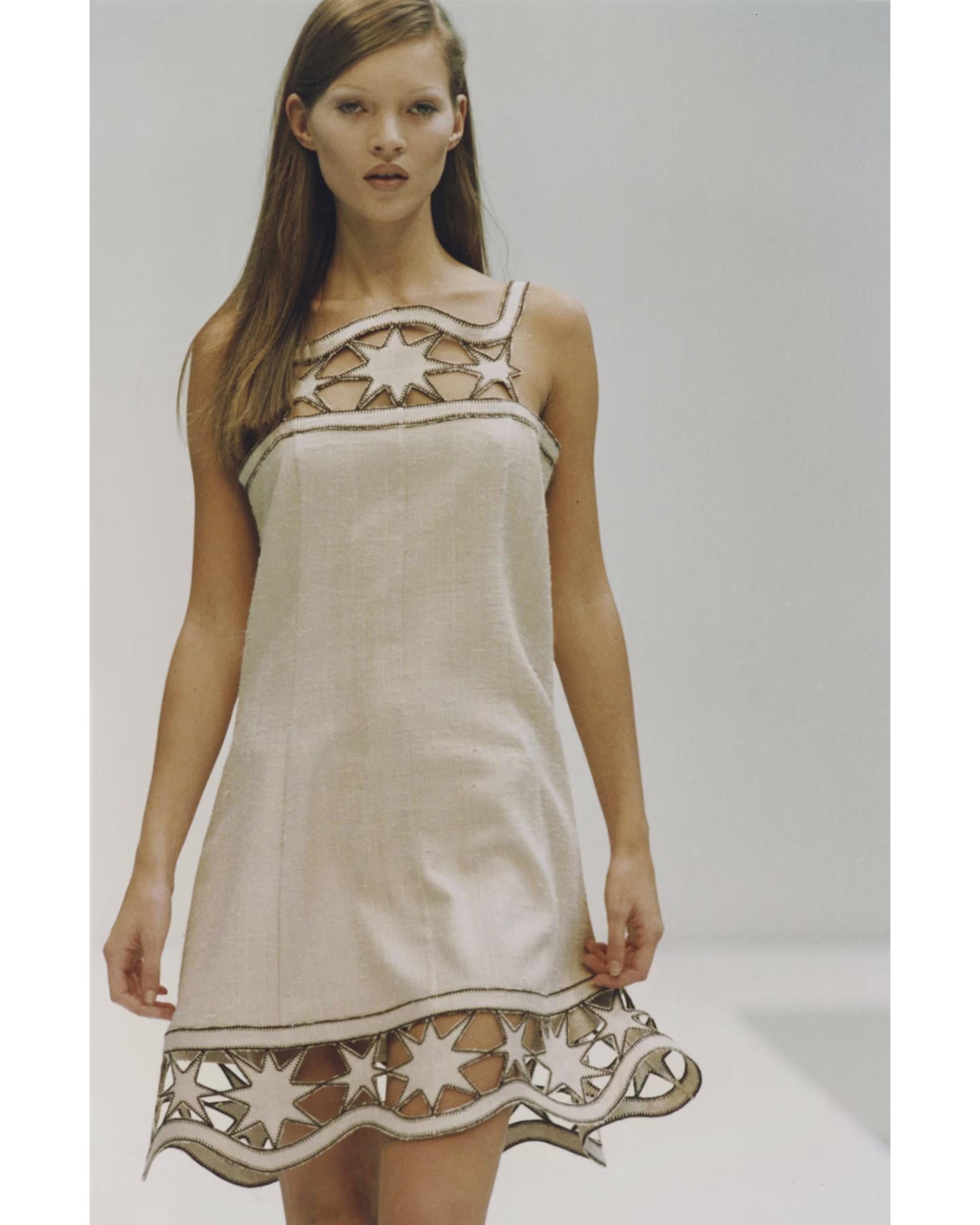 S/S 1993 Prada by Miuccia Prada toffee-colored star cutout dress. Mini dress with dark brown contrast stitched trim, featuring cutout stars at bust and hem. As seen on the runway on Kate Moss (Look 27). Designed with very soft 100% Silk that is