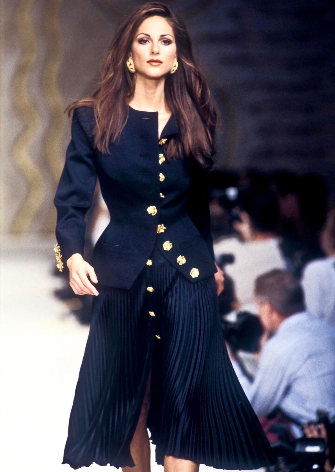 TheRealList presents: a stunning navy Valentino Boutique blazer. From the Spring/Summer 1993 collection, this blazer debuted on the season's runway modeled by Tasha de Vasconcelos. This fabulous jacket features sculptural gold-tone rose buttons at