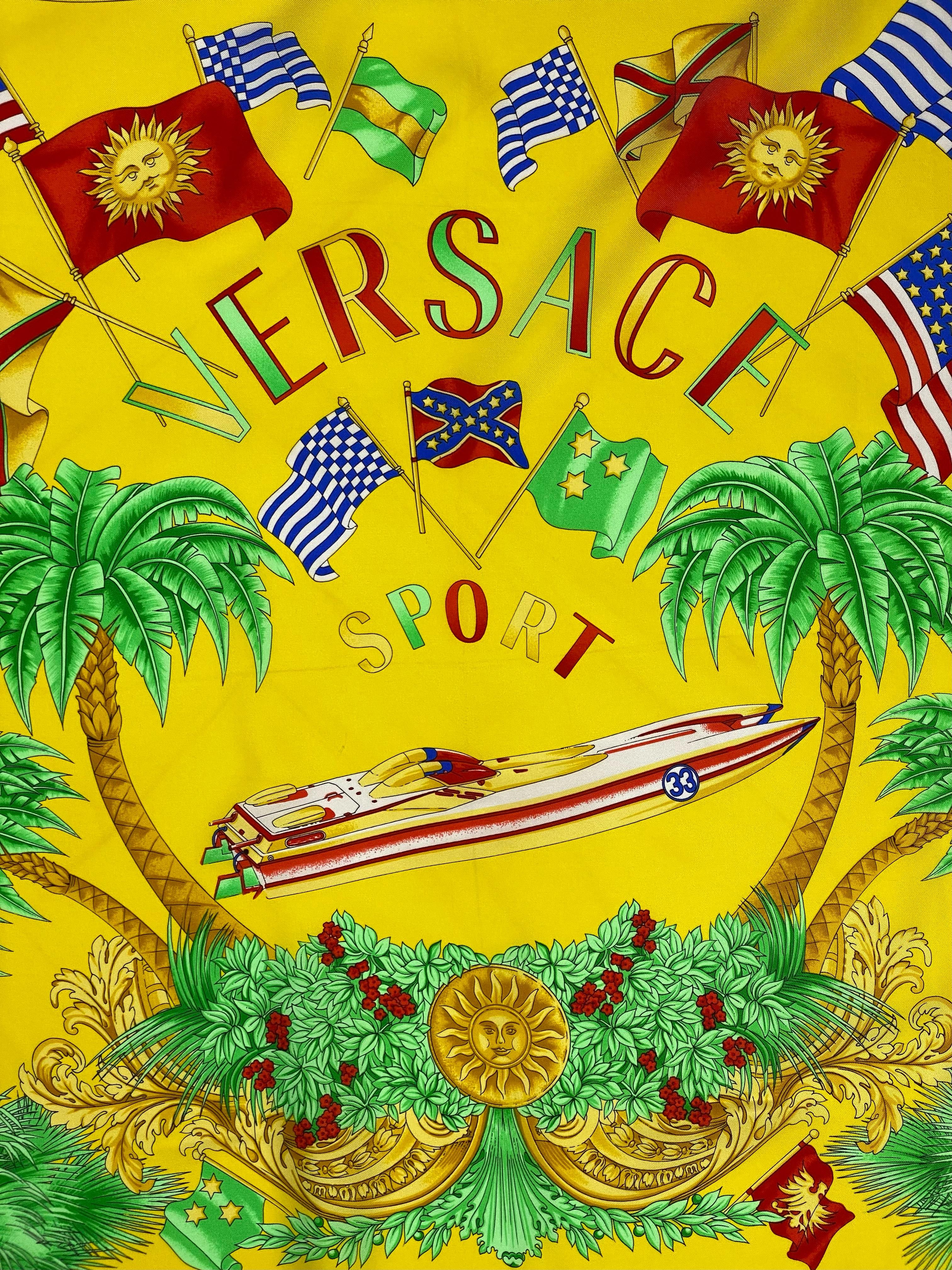 Voici un magnifique foulard carré en soie baroque, à motif de canotage à Miami, conçu par Gianni Versace. Cette écharpe présente un motif Miami avec des palmiers, des drapeaux de course et des bateaux entourés d'un motif floral baroque. Cette