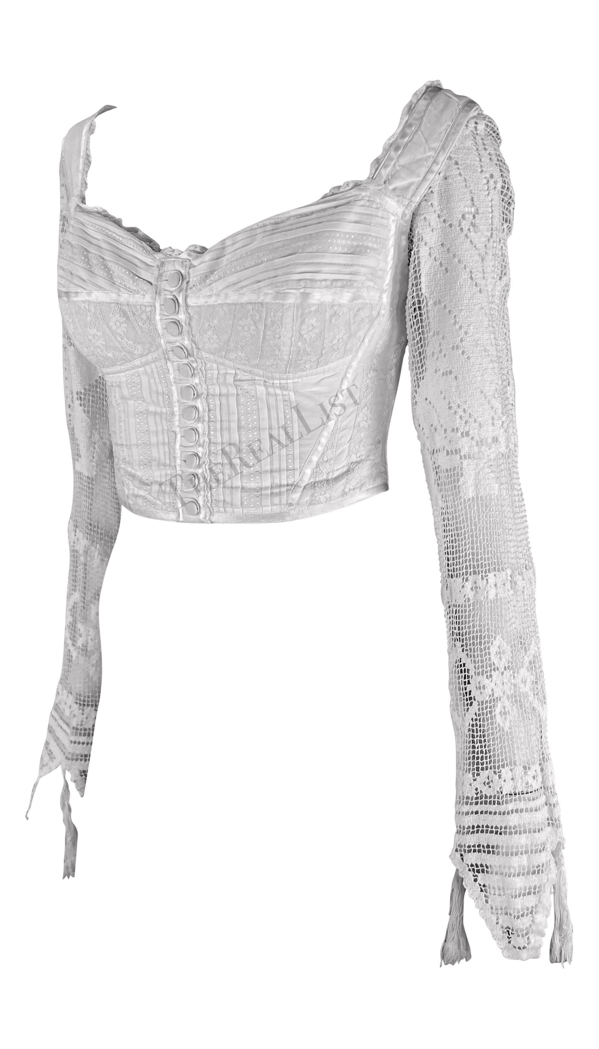 Ti presentiamo un bellissimo crop top in pizzo bianco di Dolce & Gabbana. Dalla collezione primavera/estate 1994, questo top a bustino disossato presenta una chiusura con finti bottoni sul davanti e una scollatura a cuore. Questo favoloso top è