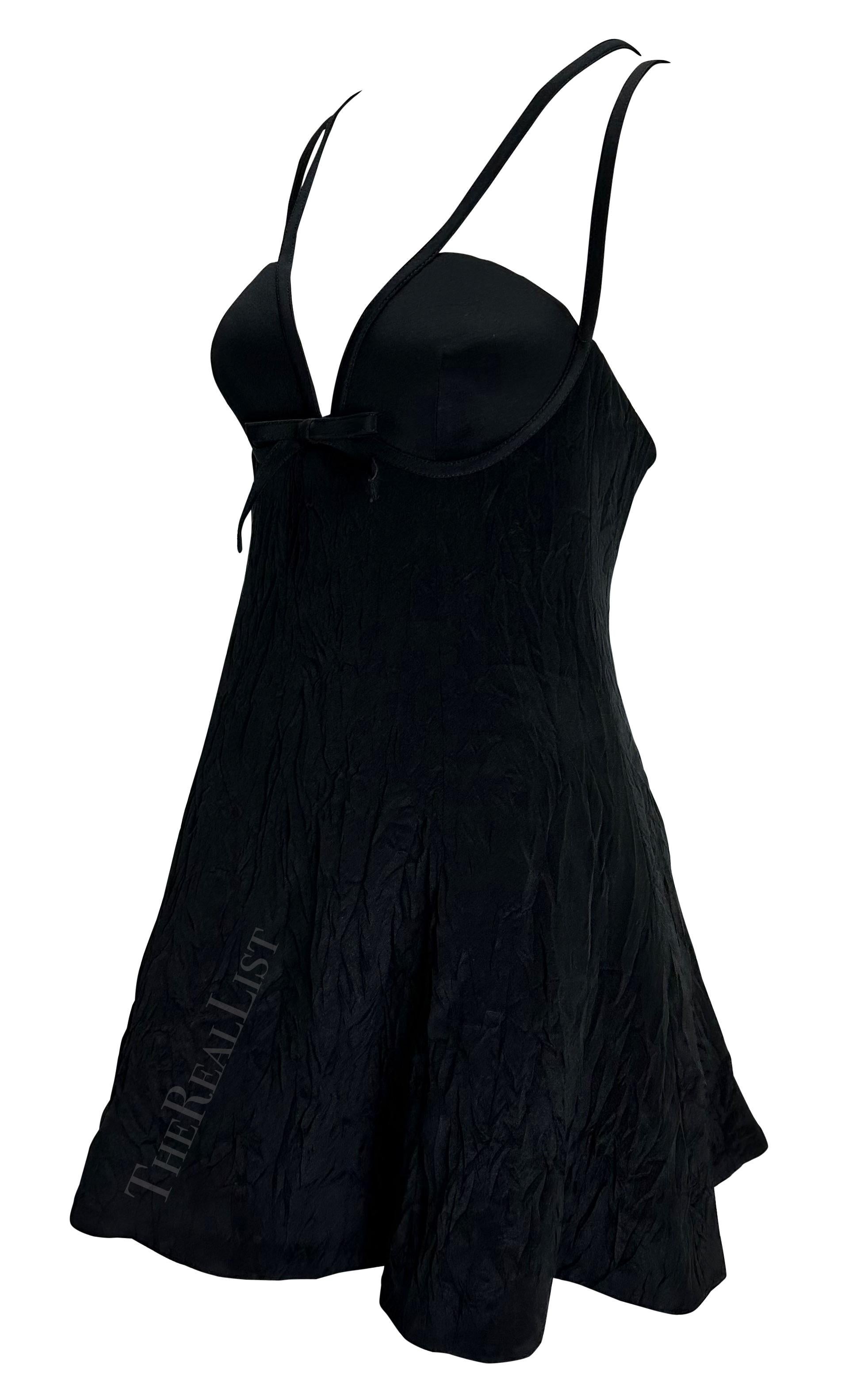 Voici une superbe robe noire de baby doll de Gianni Versace, créée par Gianni Versace. Issue de la collection printemps/été 1994, cette mini robe présente une jupe évasée volontairement froissée et est complétée par des bretelles spaghetti qui se