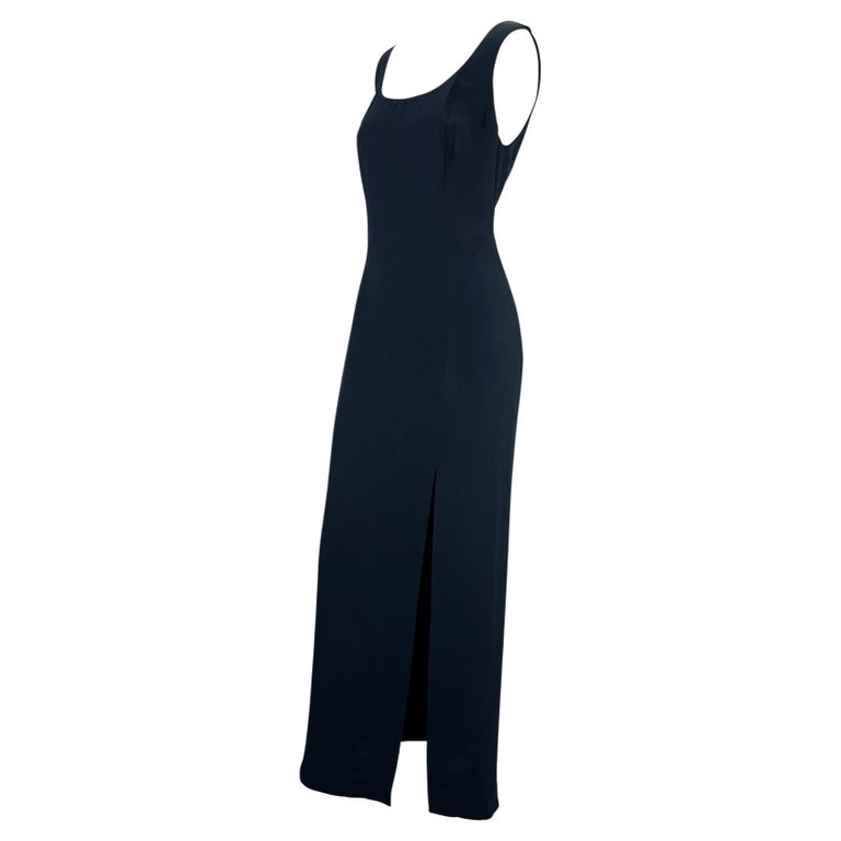 TheRealList presents: a stunning sleeveless navy blue Gianni Versace Couture gown, designed by Gianni Versace. From the Spring/Summer 1994 collection, this elegant and timeless gown features a wide scoop neckline and a high slit at the front. This