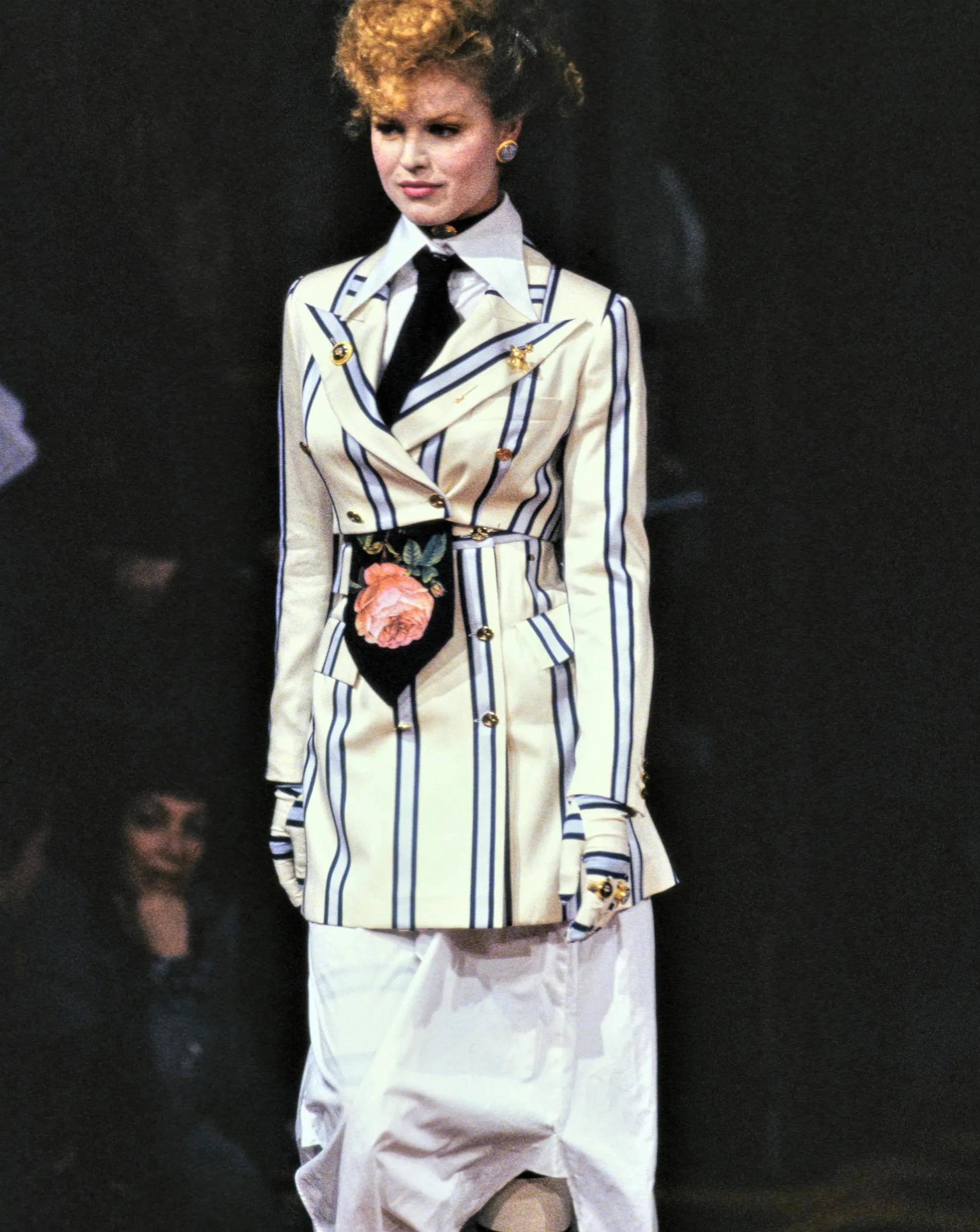 S/S 1994 Vivienne Westwood 'Cafe Society' Collection striped skirt suit set with built-in corset. Cropped black double-breasted blazer jacket and mini skirt with purple, white, green and navy stripes throughout. Features signature gold Westwood Orb